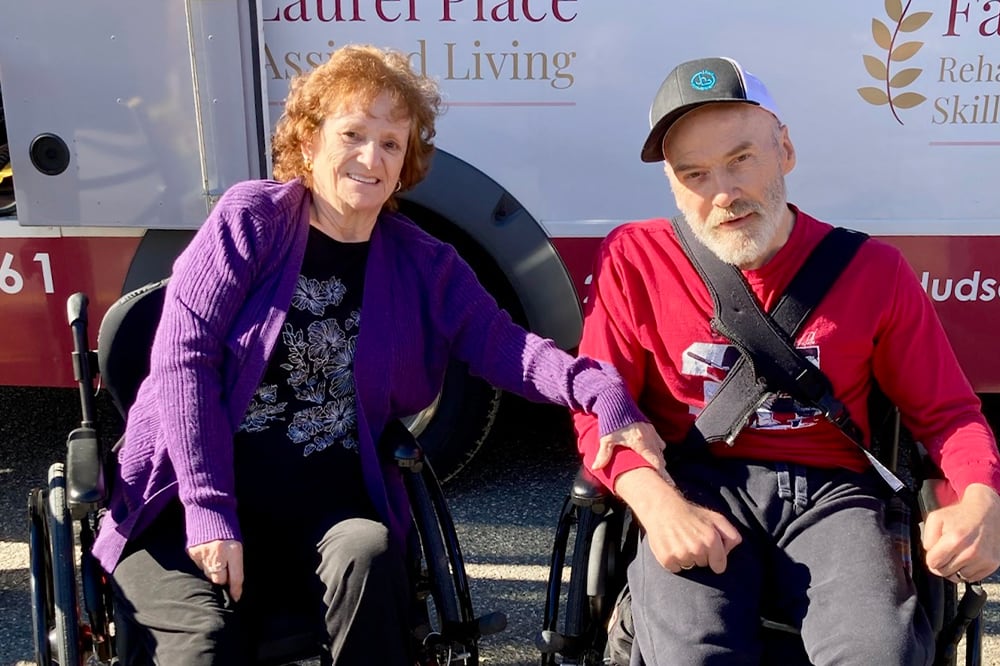 Two residents enjoying time together outdoors in wheelchairs