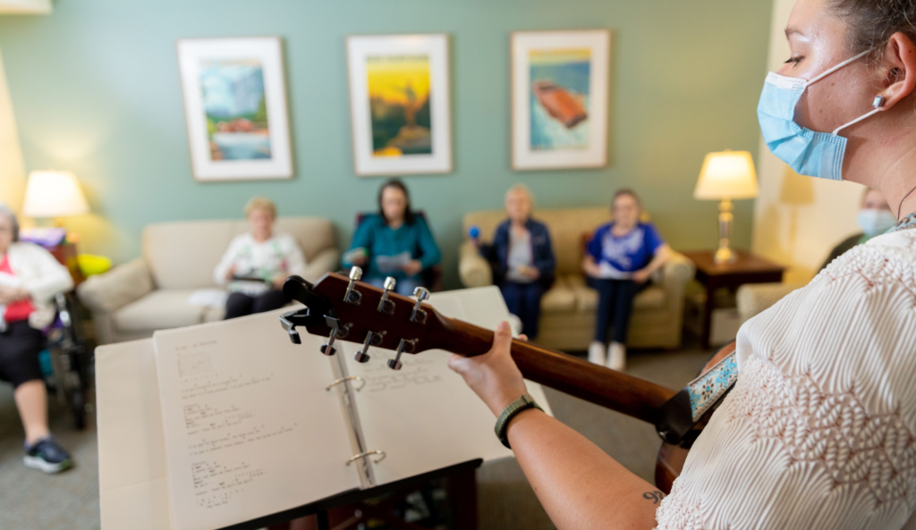 A music therapist performing for residents in a common area