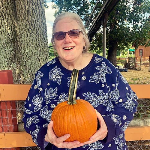 Resident enjoying a pumpkin during an outdoor activity