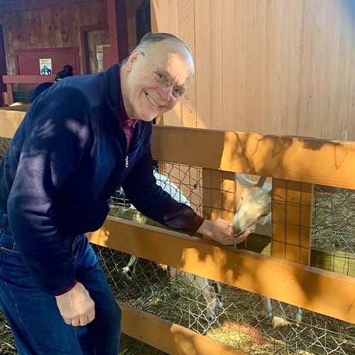 Resident interacting with a goat at a petting area