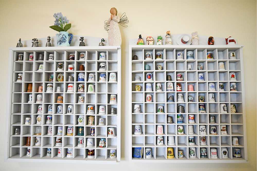 A display of various collectible thimbles on shelves