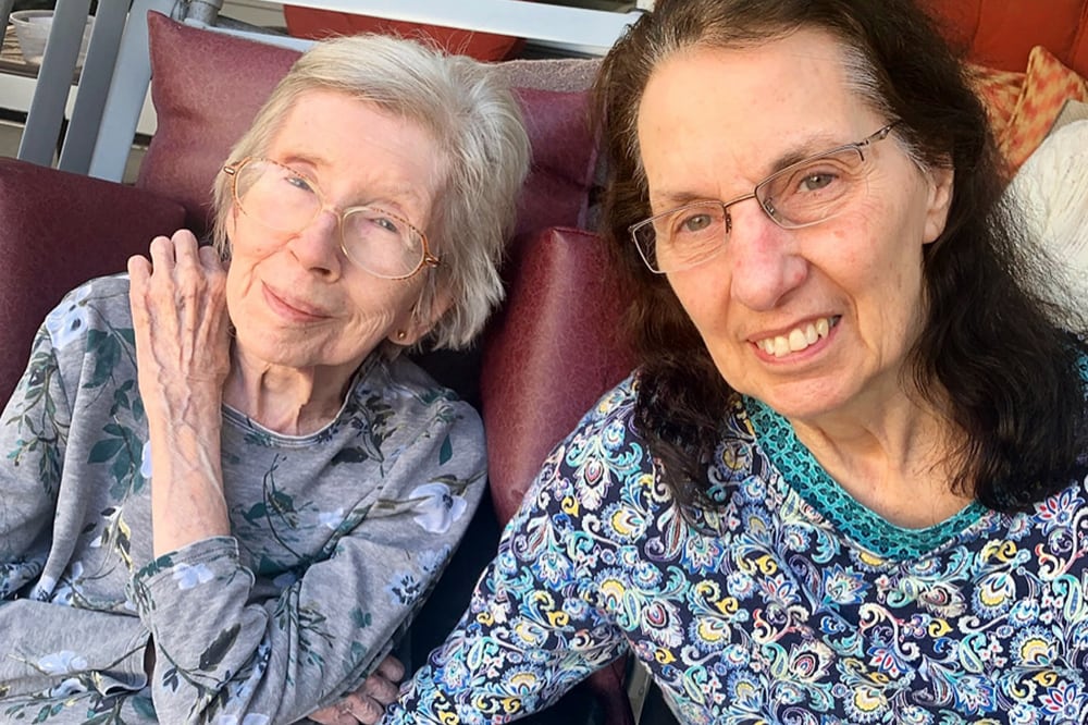 Two residents smiling together outdoors