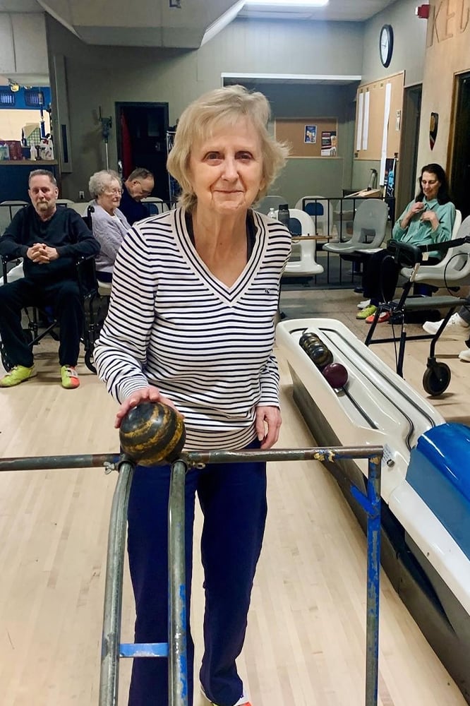 Resident participating in an indoor bowling activity