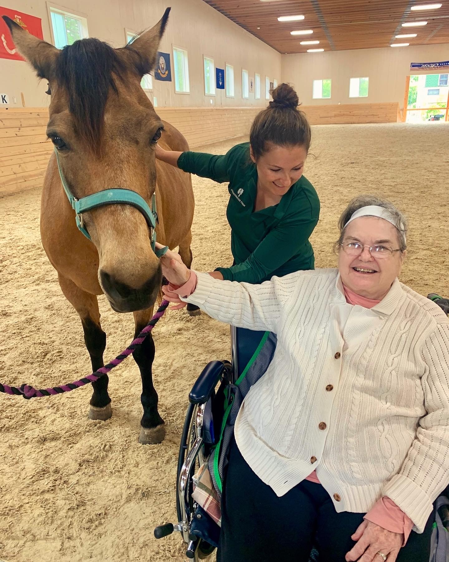Resident interacting with a horse accompanied by staff