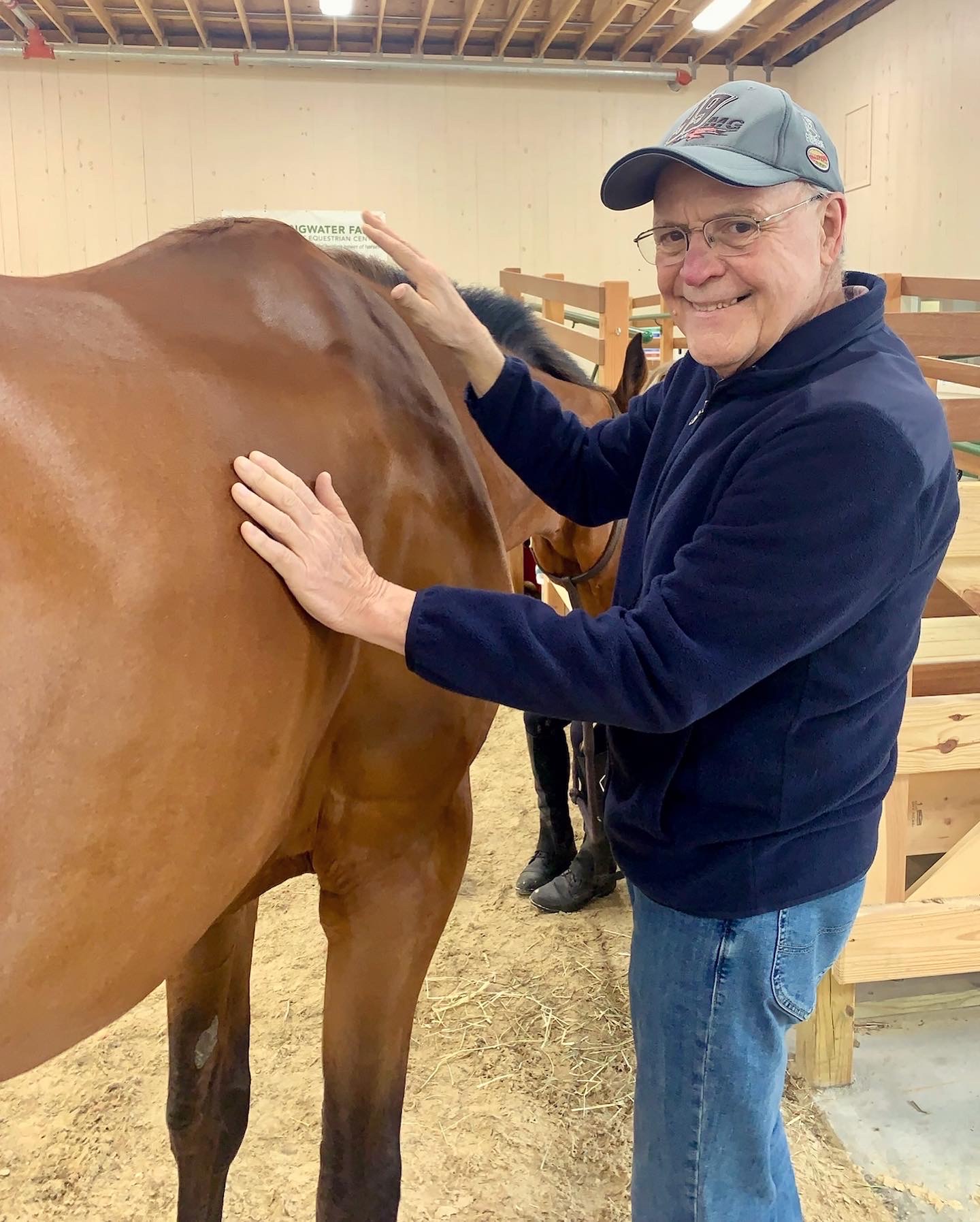 Senior resident interacting with a horse in an indoor setting