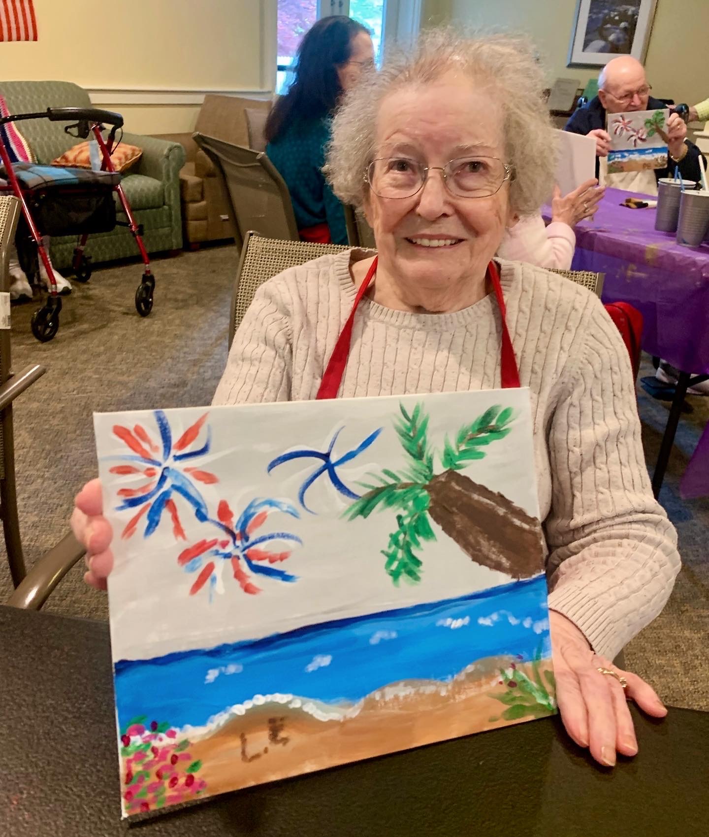 Resident painting a colorful beach scene during an activity