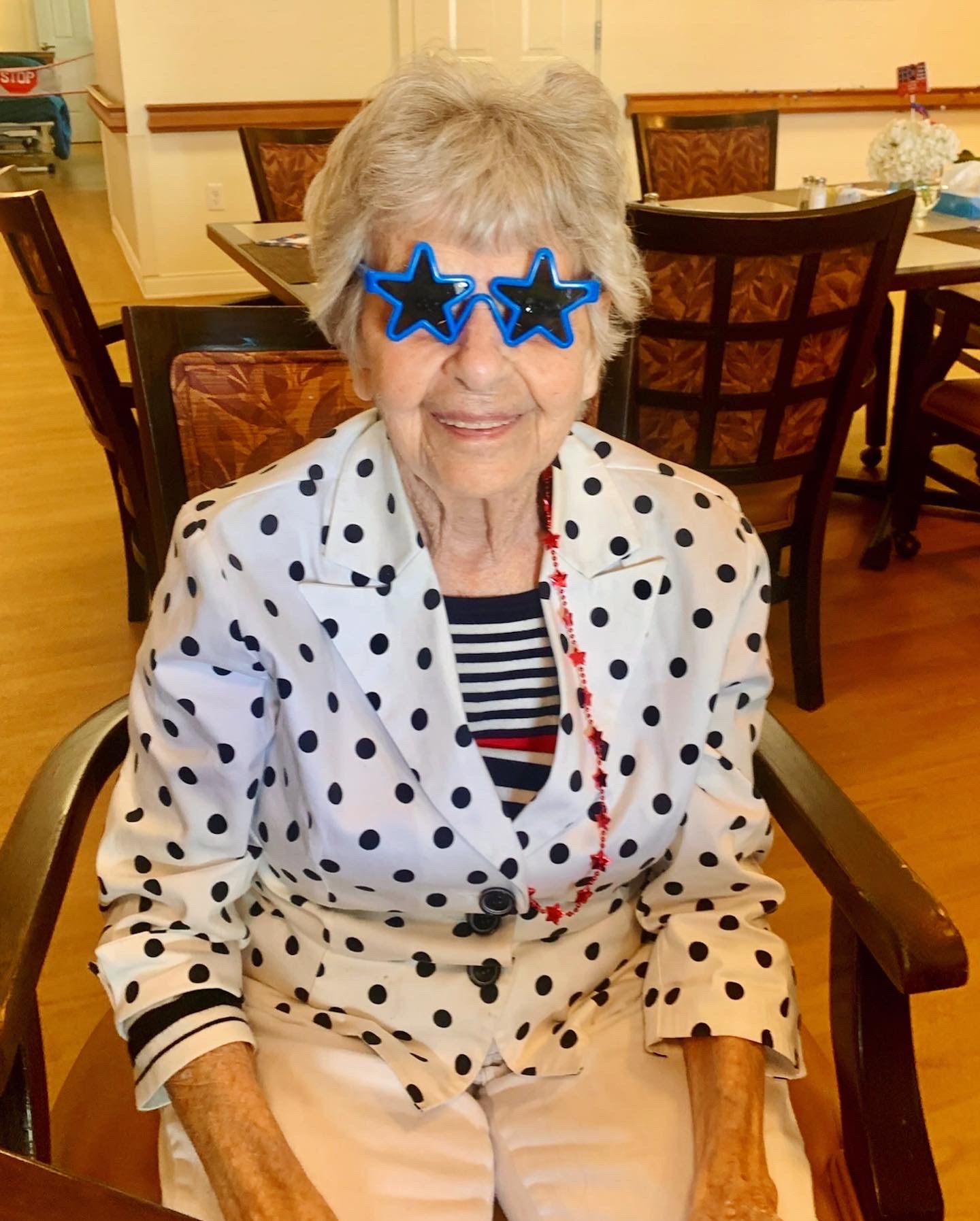 Resident wearing fun star-shaped sunglasses in dining area