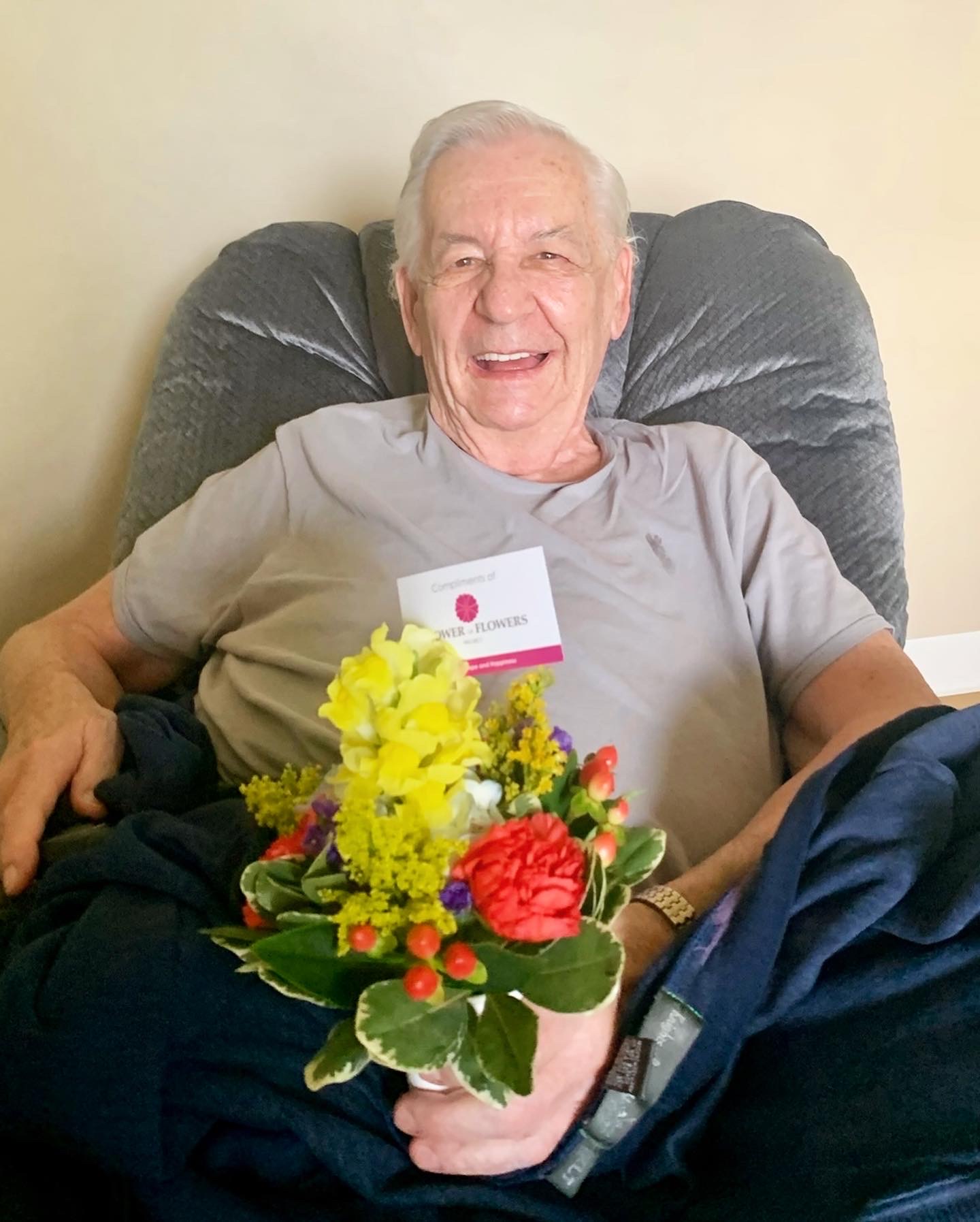 Resident holding a bouquet of flowers and smiling