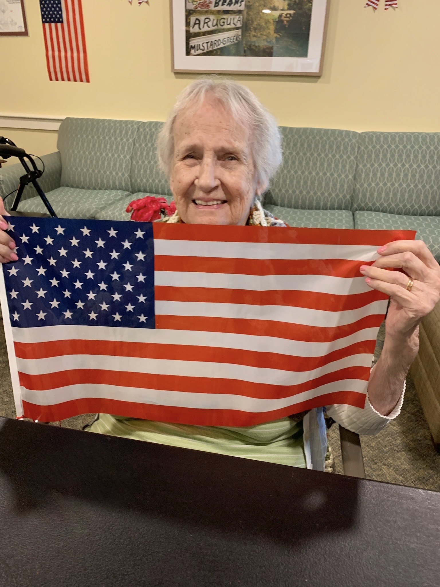 A smiling resident holding an American flag