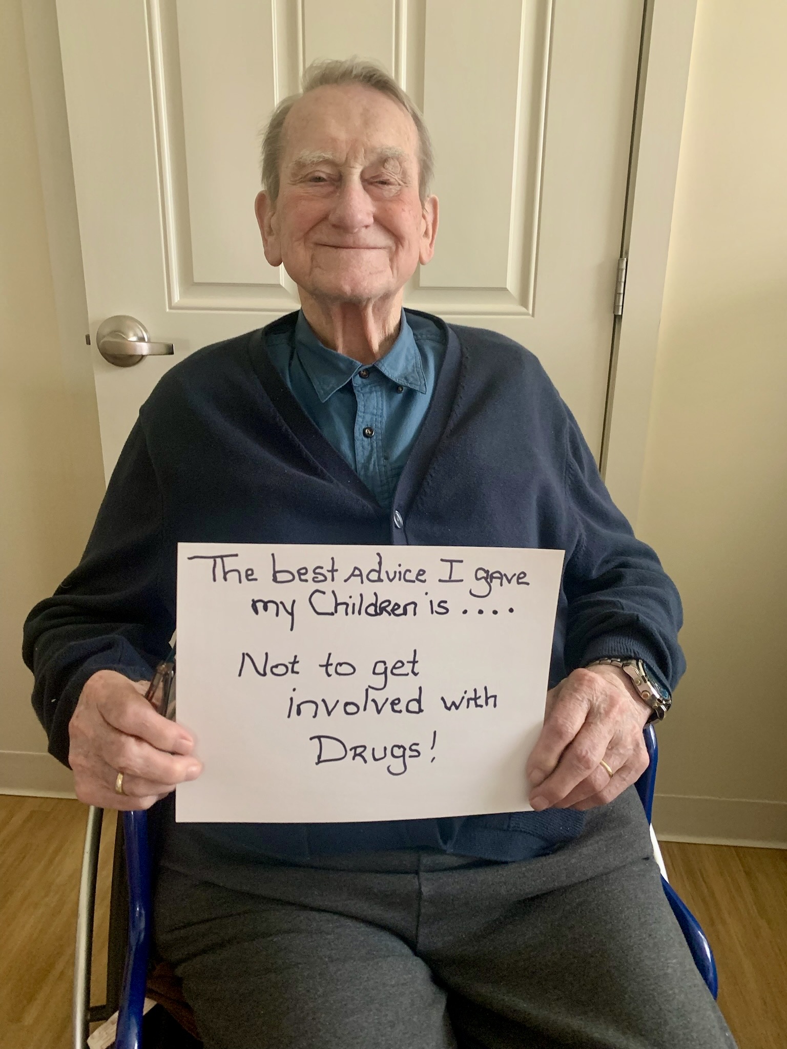 Resident sharing advice with a sign in a facility room
