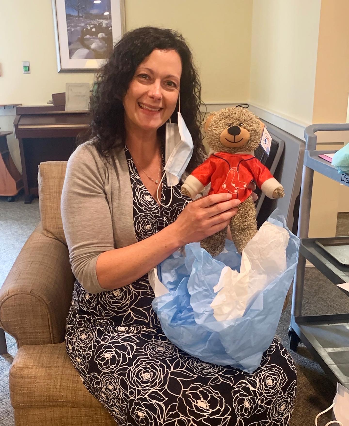 Staff member holding a teddy bear in a common area