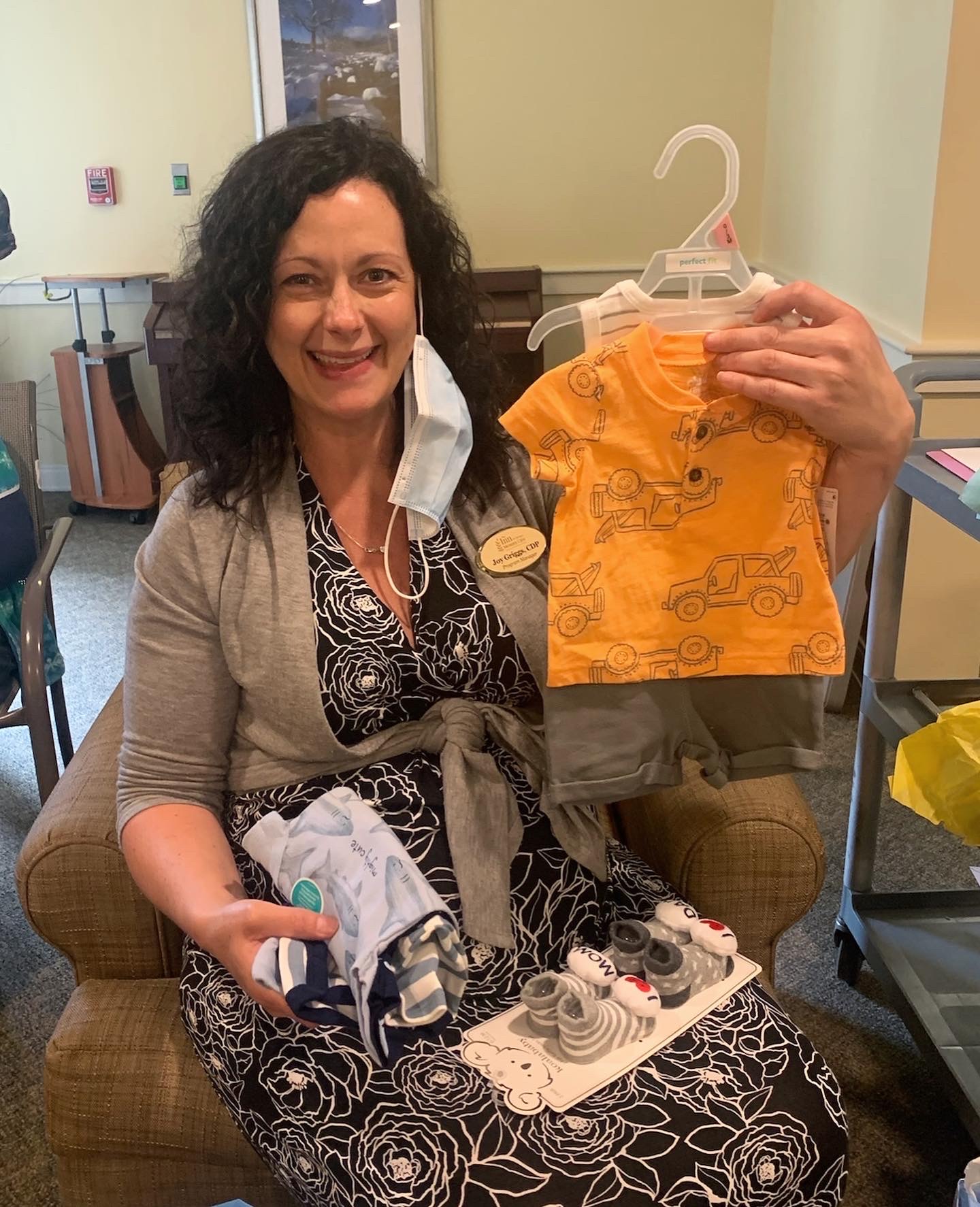 Staff member showing clothes donations for residents