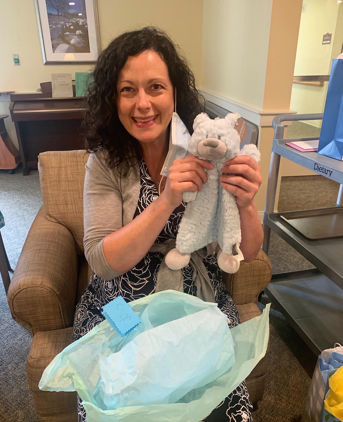 Staff member holding a stuffed animal gift