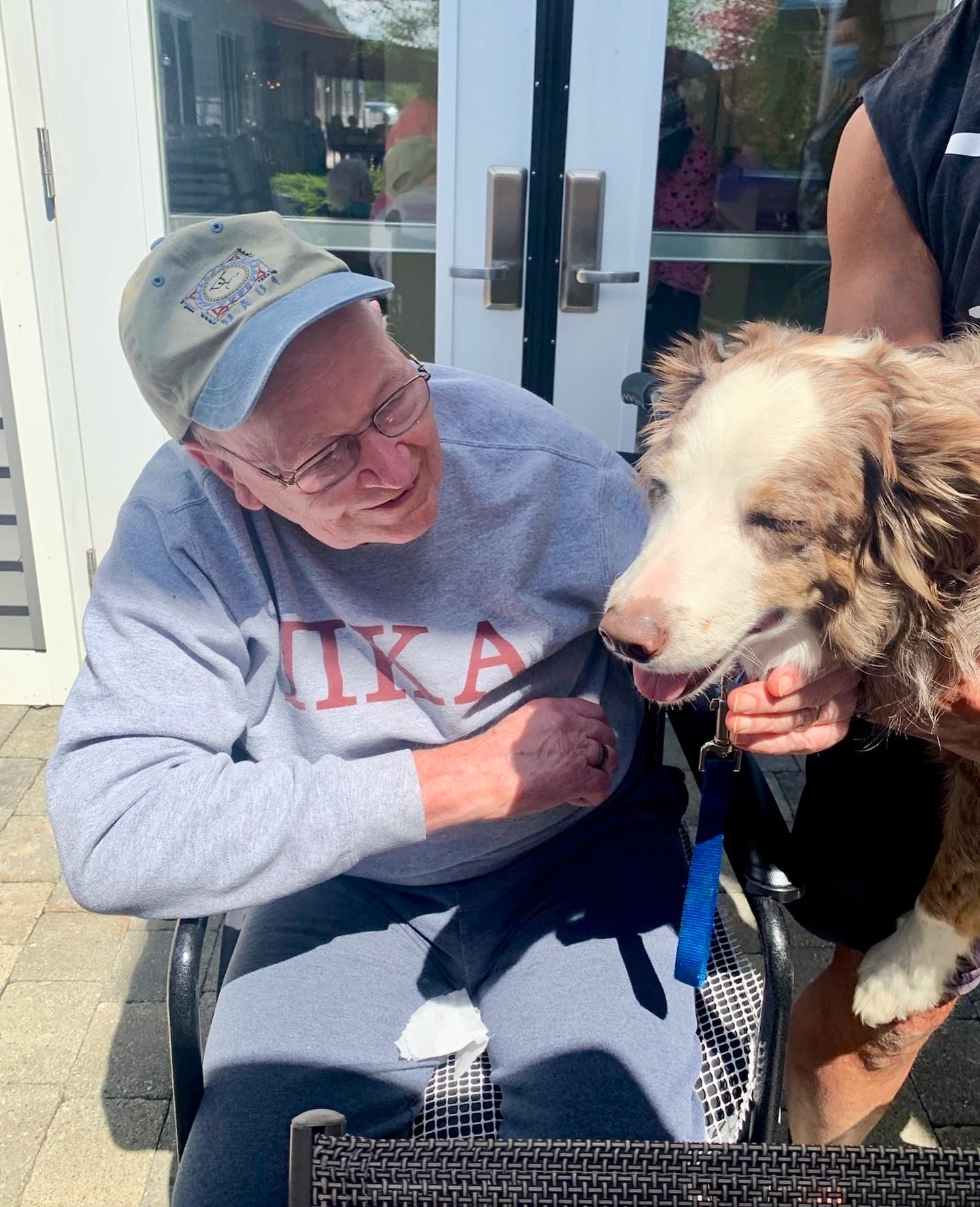 A resident smiling with a dog outdoors
