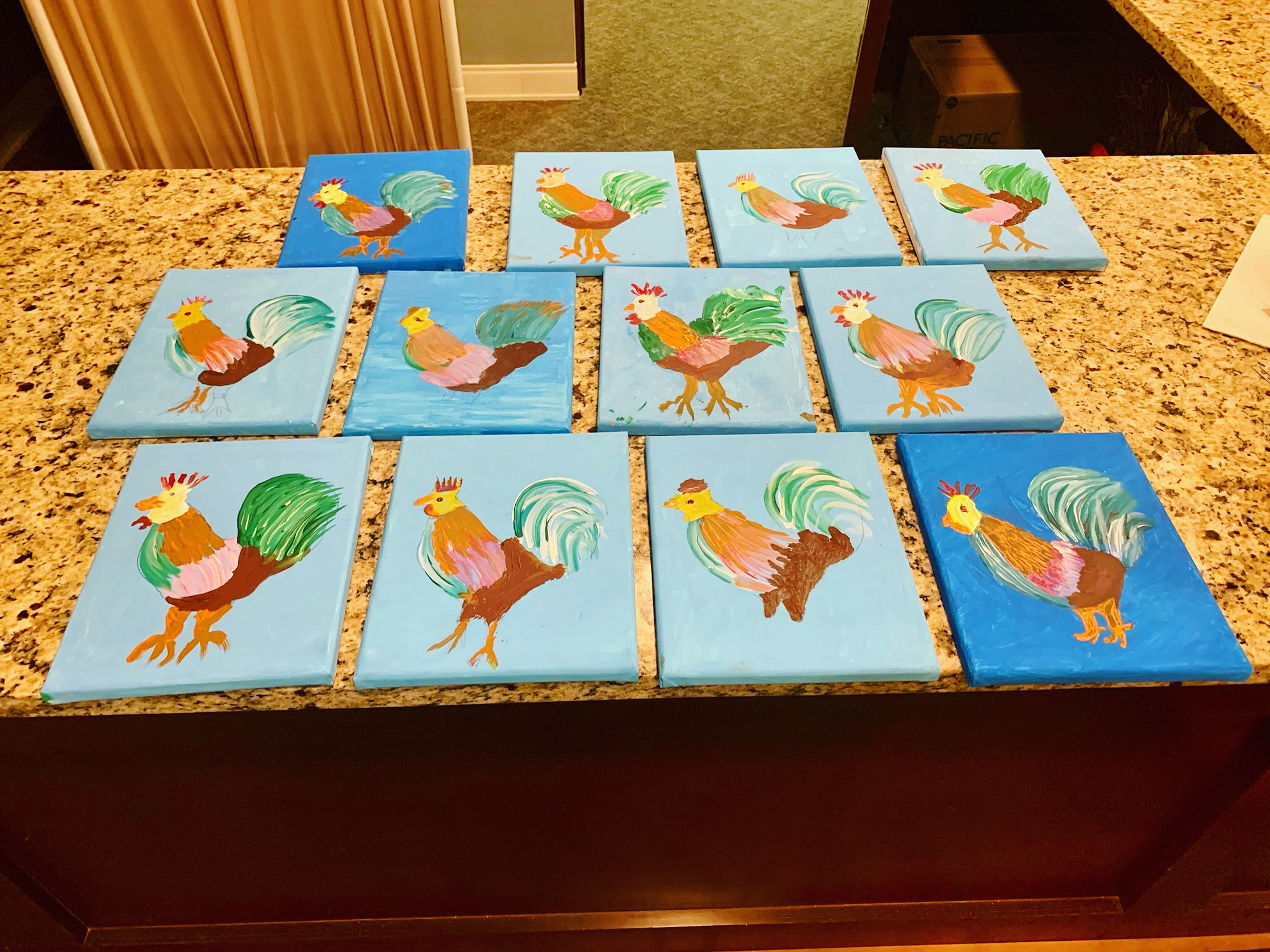 Colorful handmade chicken paintings displayed on a countertop
