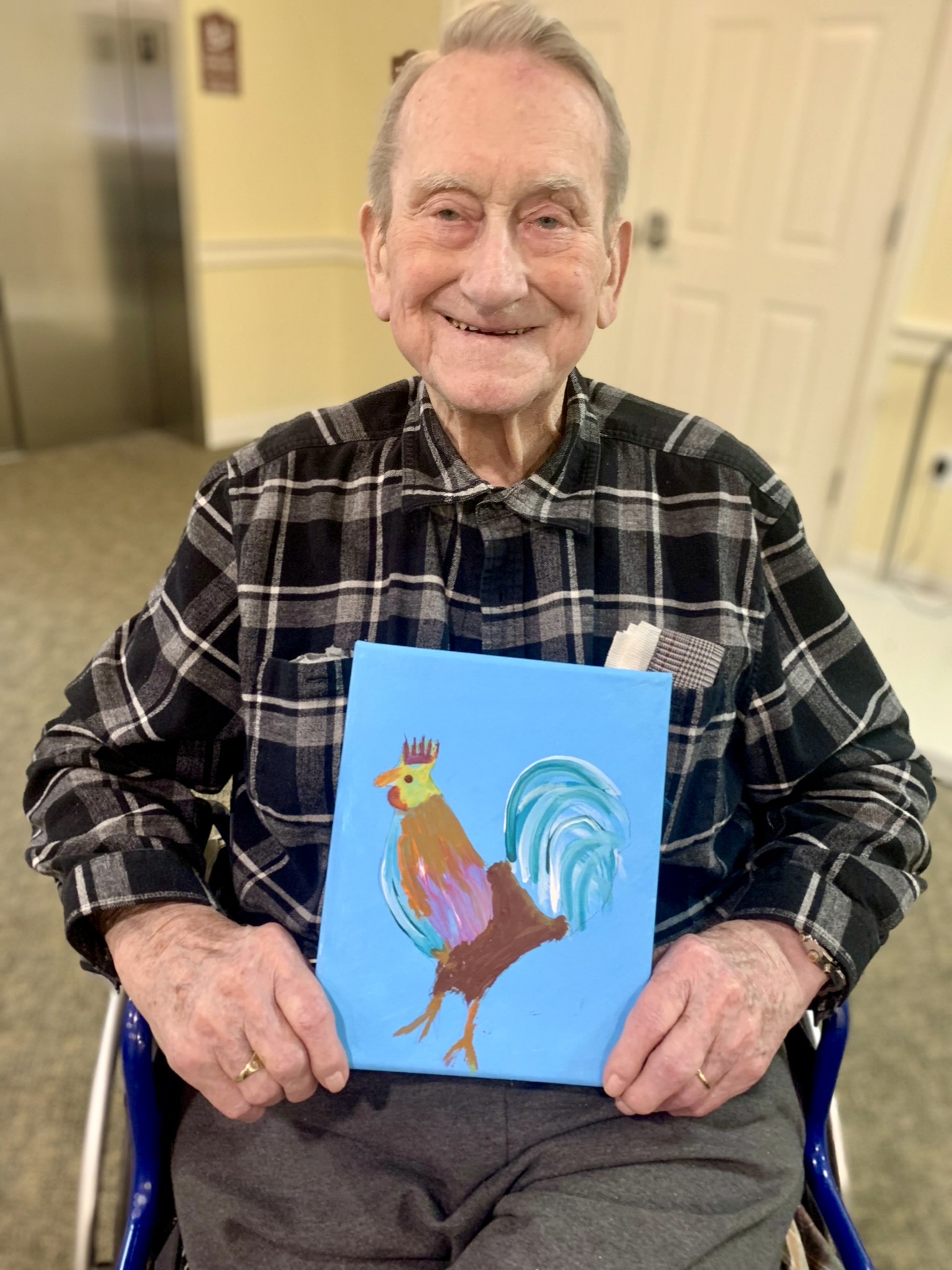 Resident holding a painting in a common area