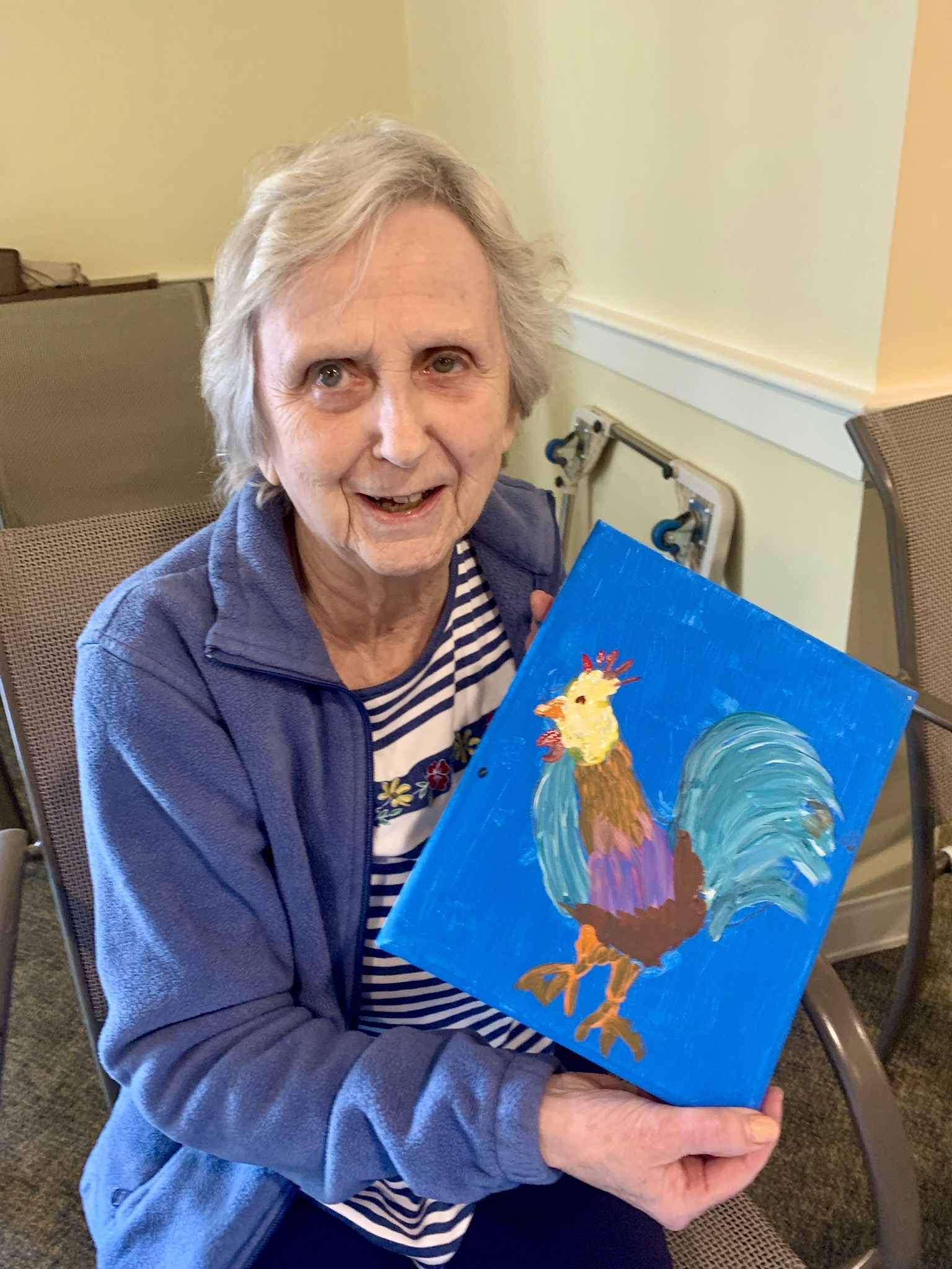 Resident showcasing artwork in an activity room