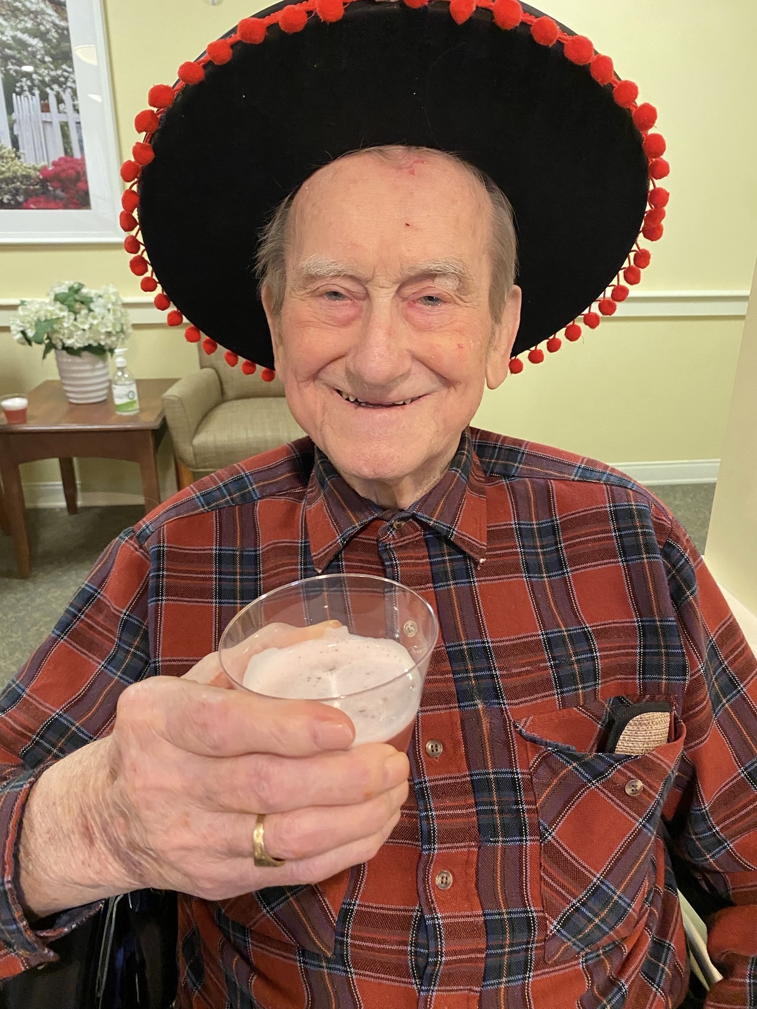 Elderly man smiling wearing a festive hat
