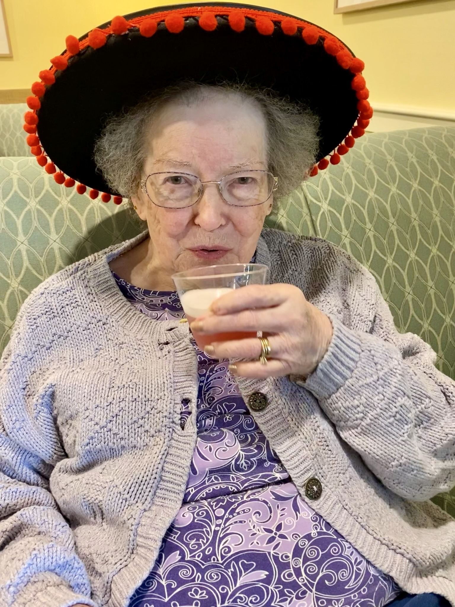 Resident enjoying a drink with a festive hat