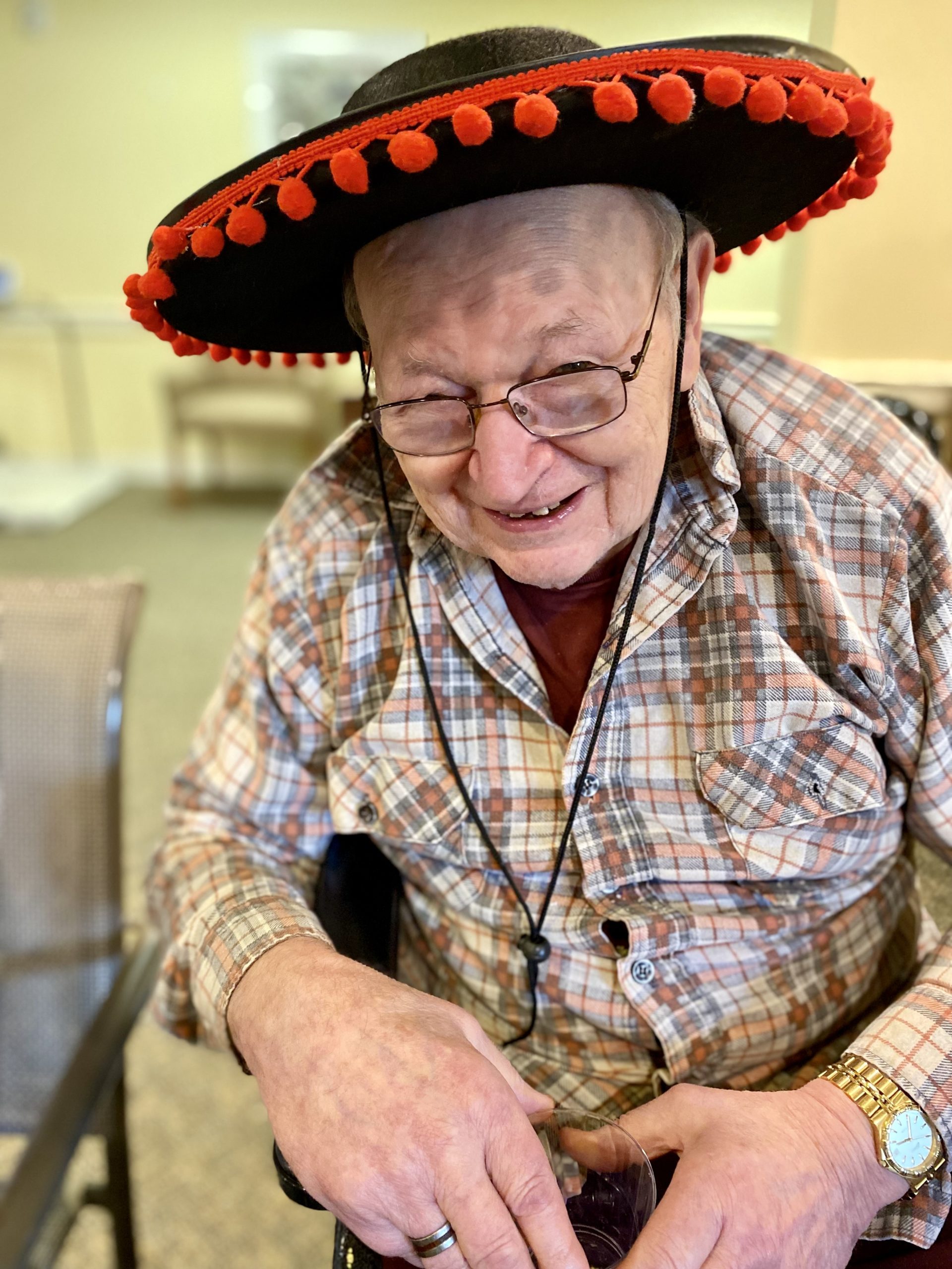 A resident wearing a colorful sombrero and smiling