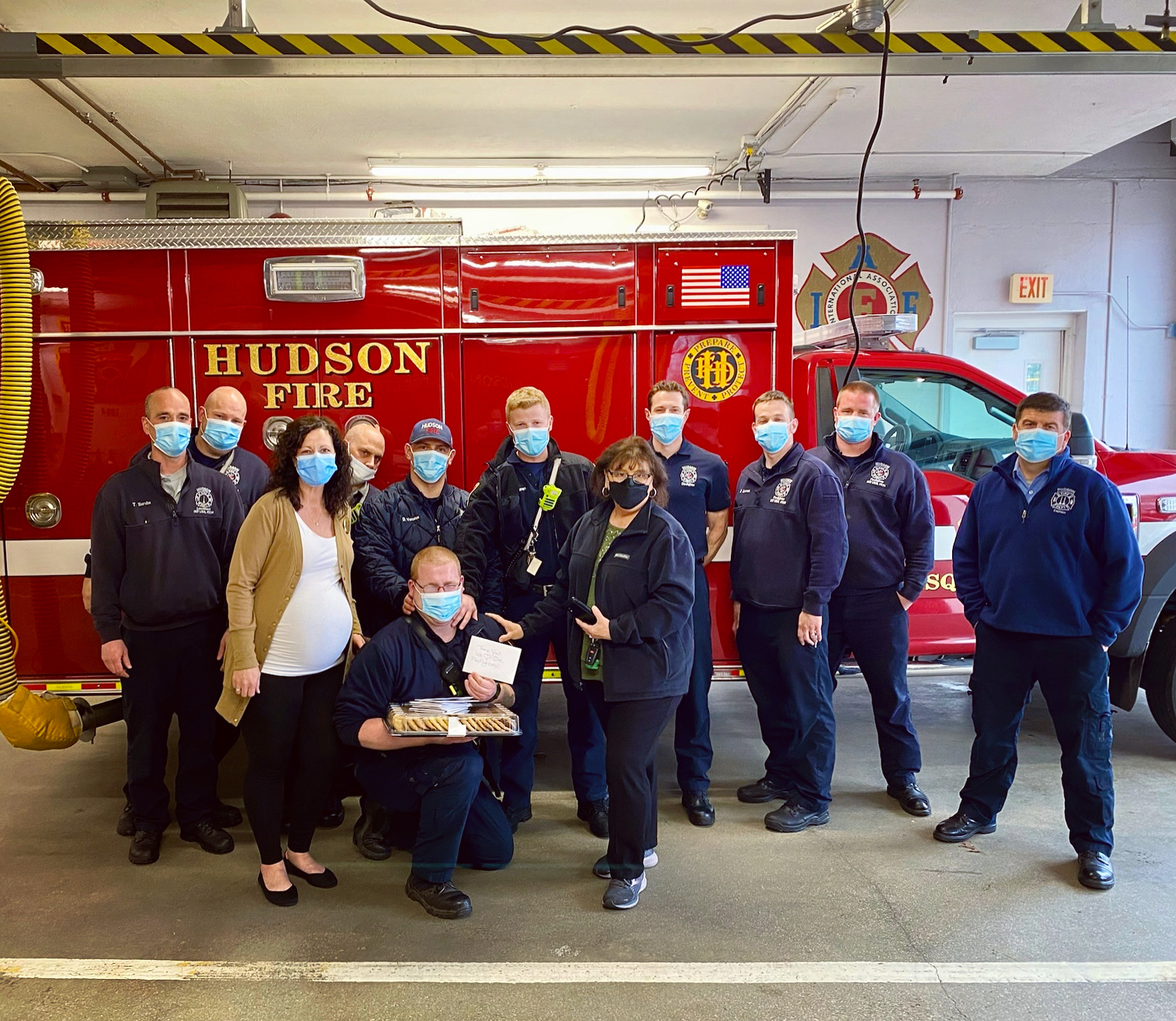 Staff and firefighters posing together indoors