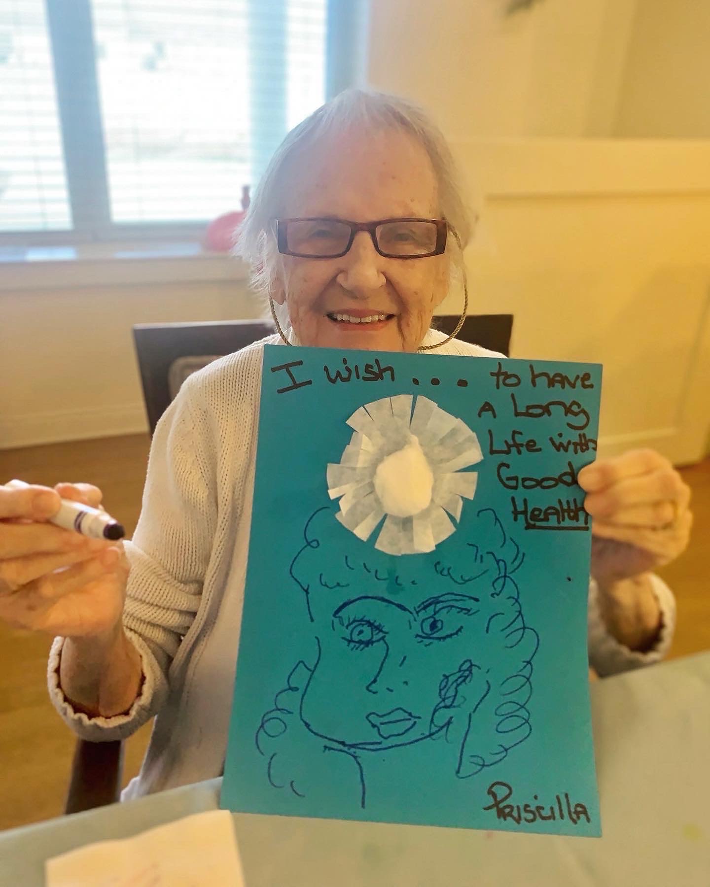 Elderly resident holding an artwork with a positive message