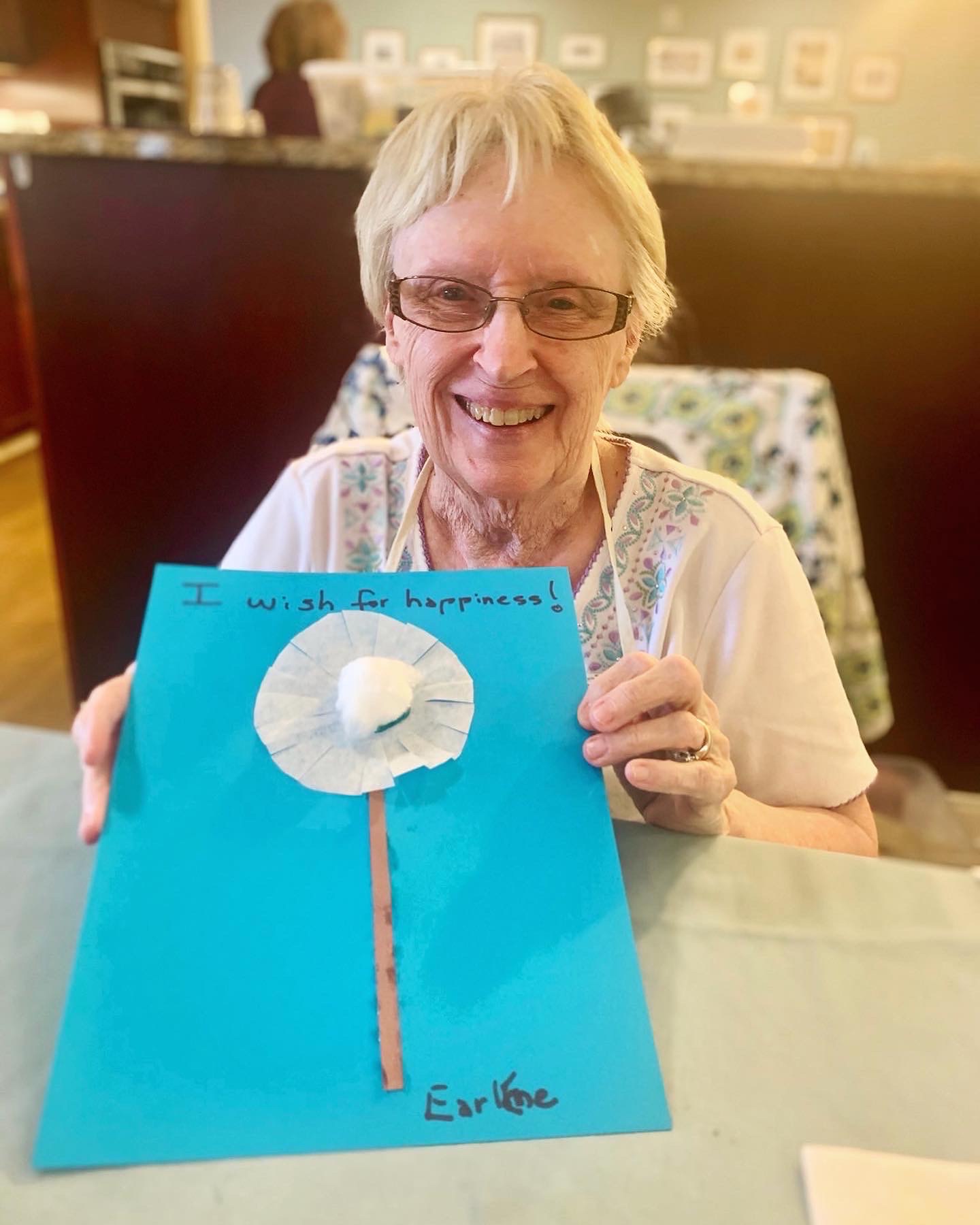 Resident holding a handmade art project with a positive message
