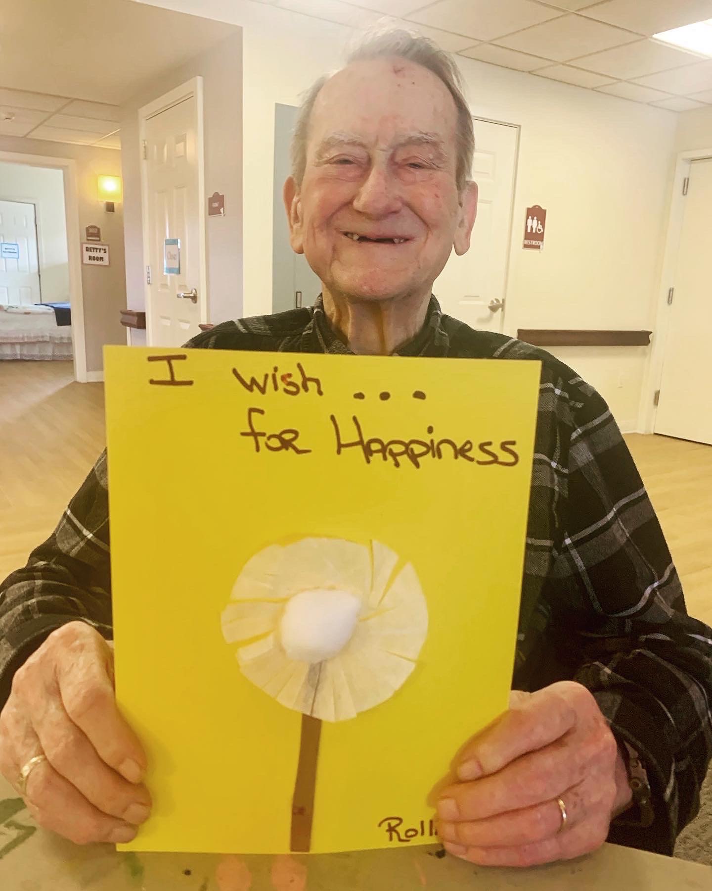 Resident smiling with an artwork for happiness