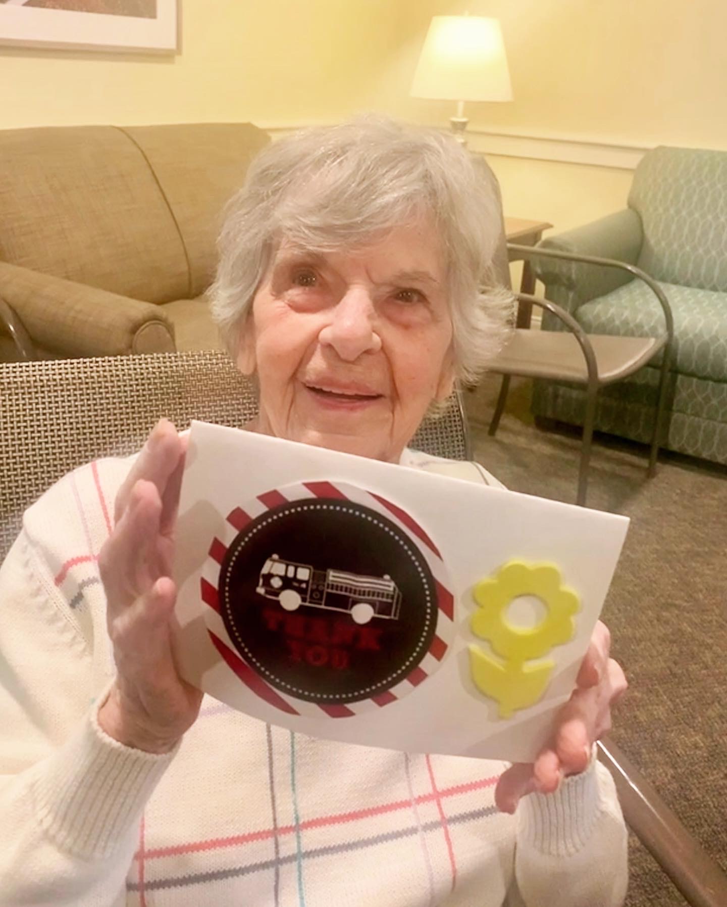 A resident holding a decorated card in an interior space