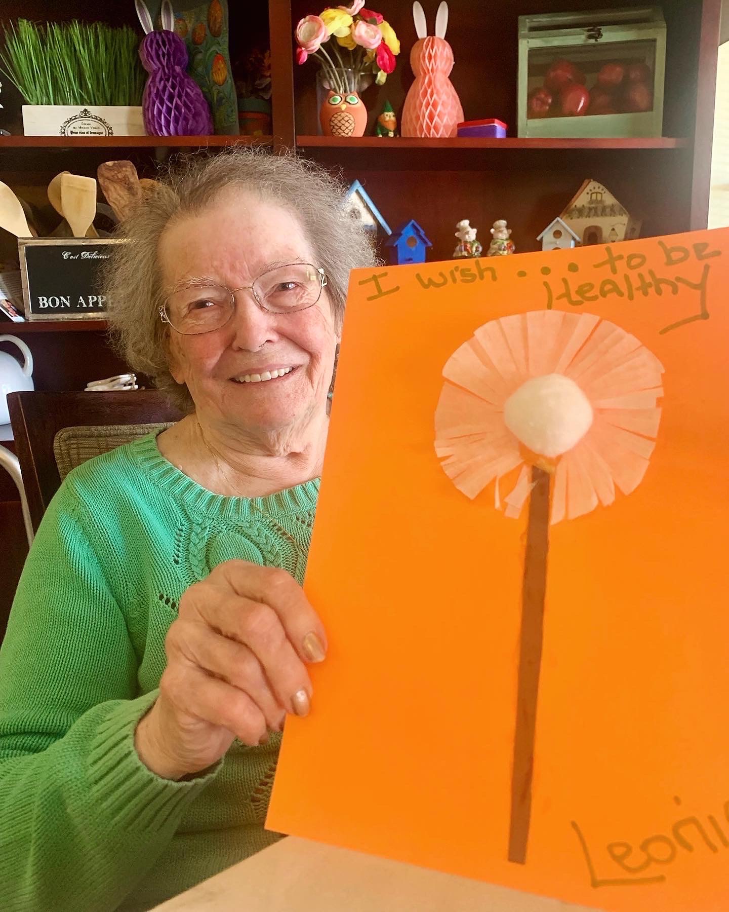 A resident proudly displaying her artwork