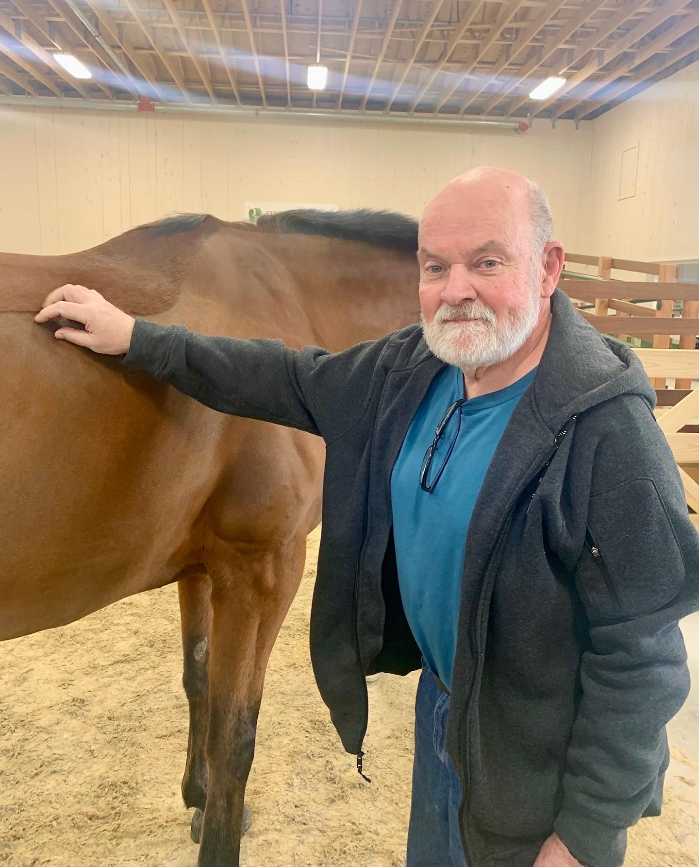 A man interacting with a horse in an indoor setting