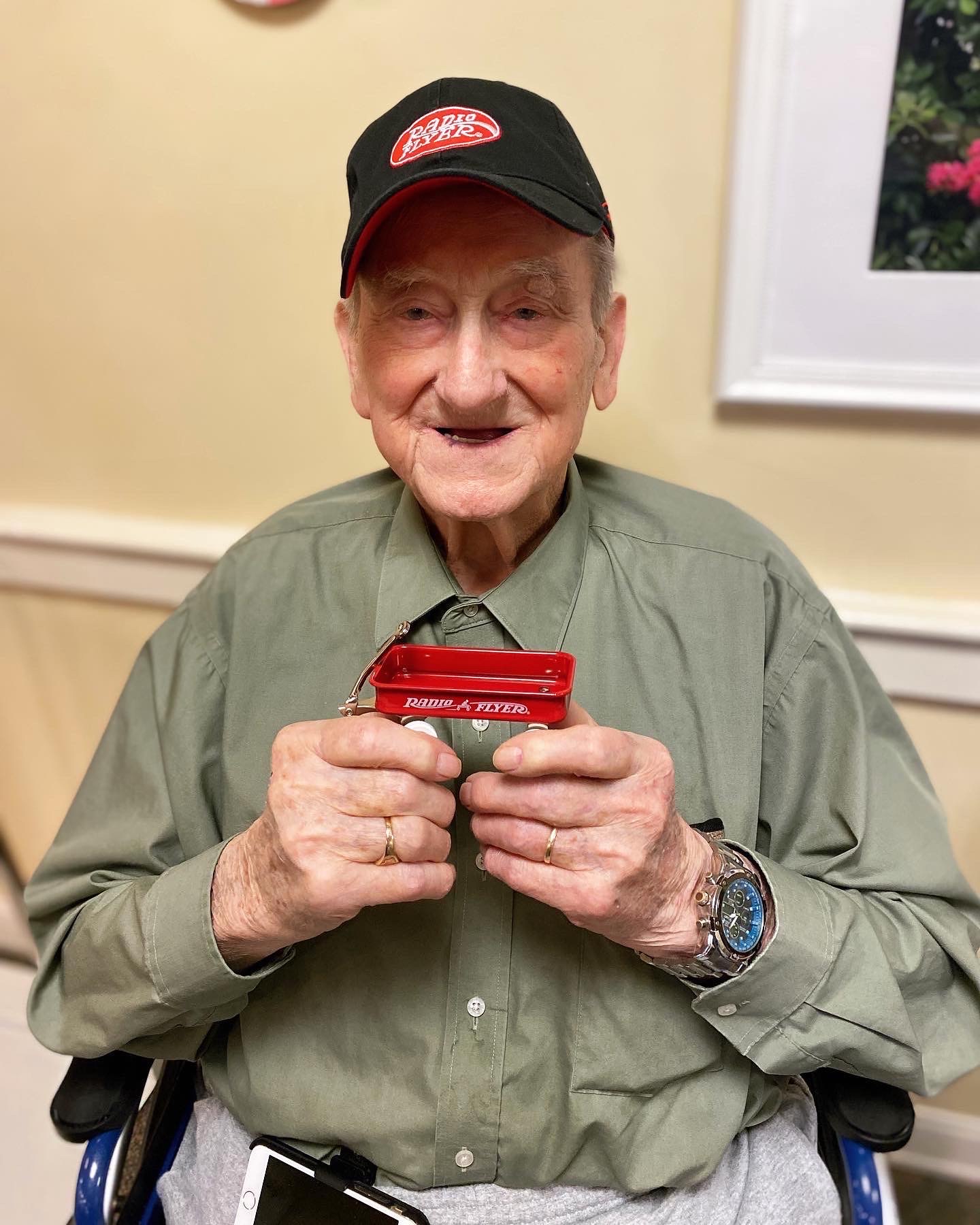 Resident proudly holding a harmonica in a common area