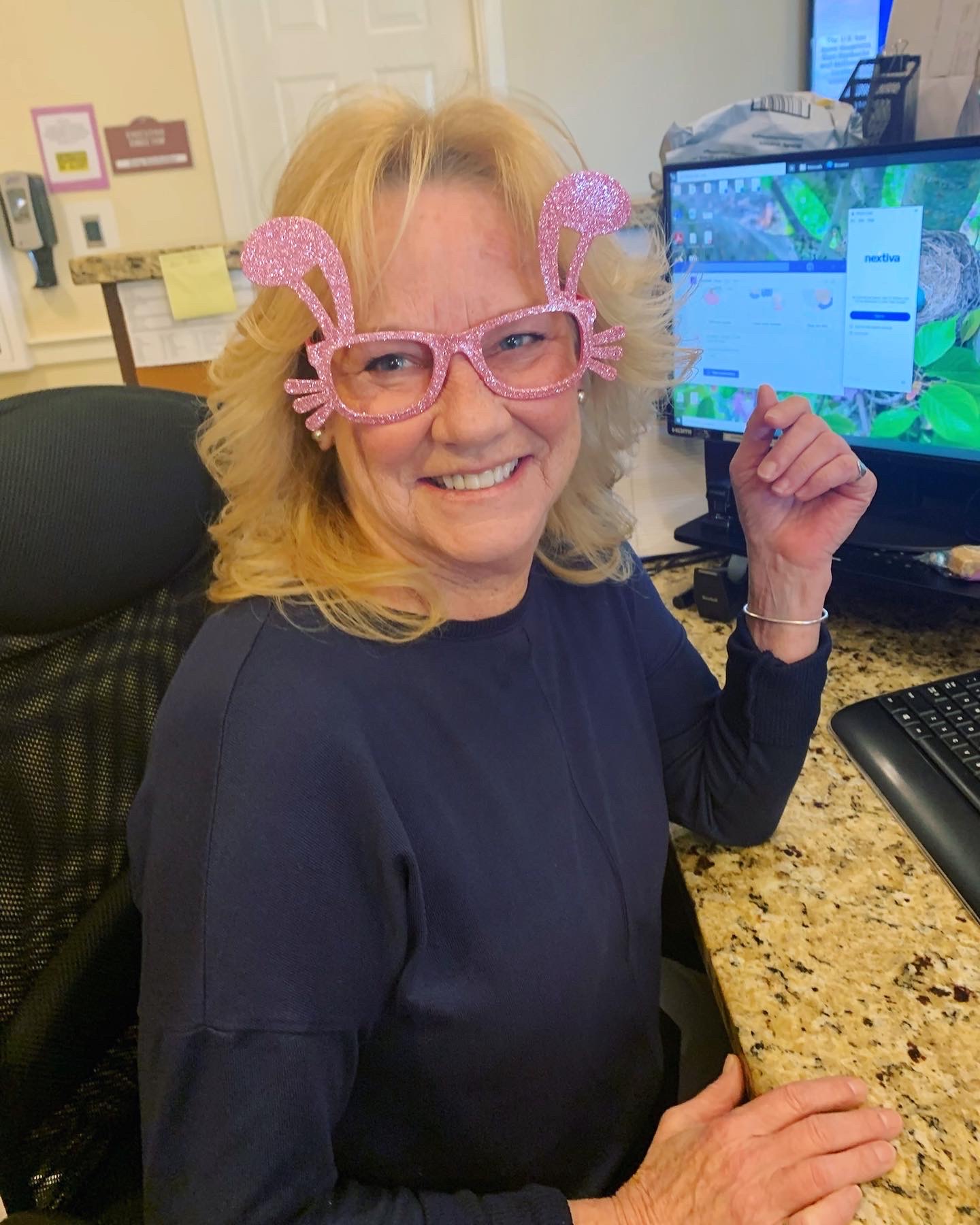 Happy resident wearing fun glasses at her desk