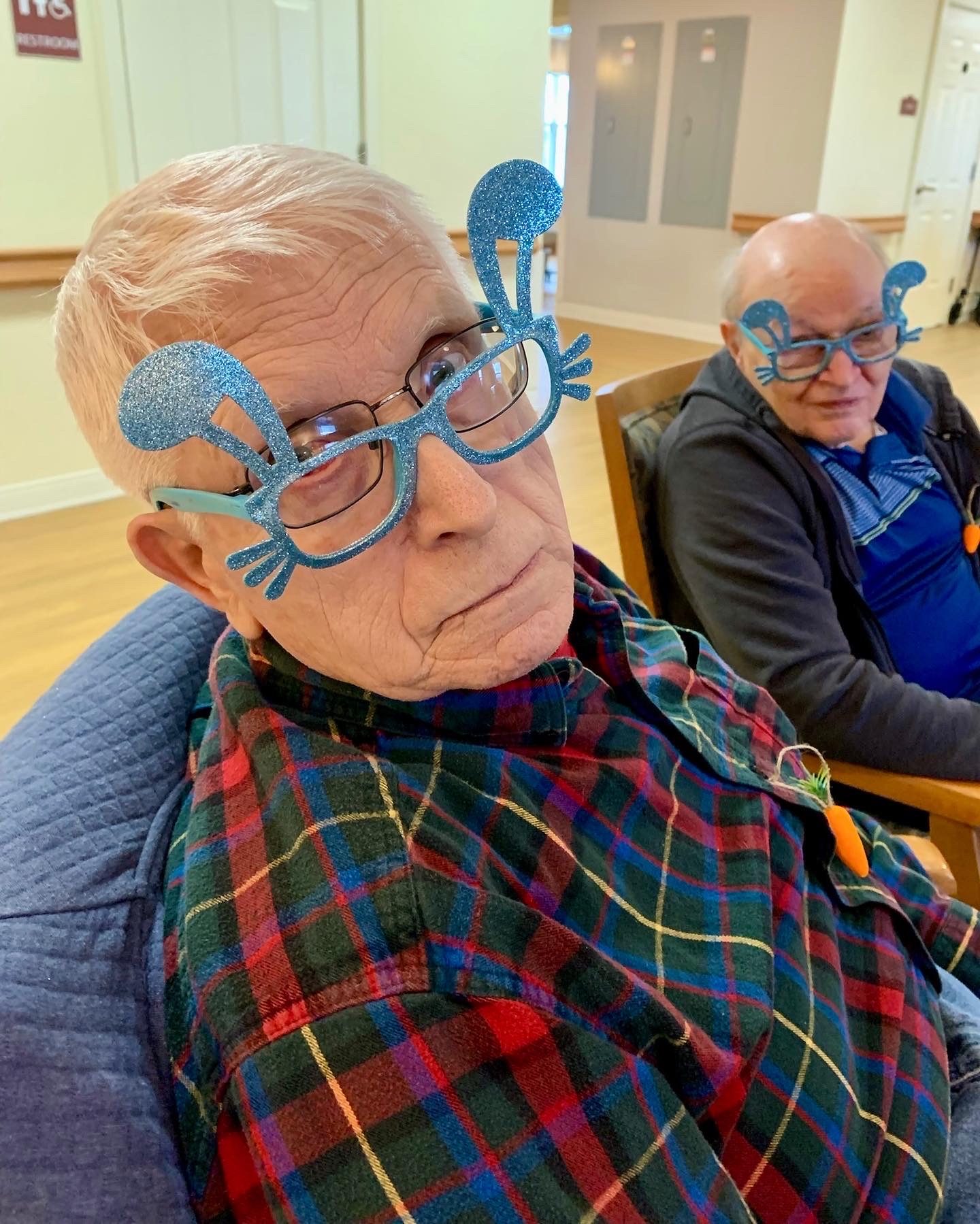 Residents participating in a fun activity with decorative glasses