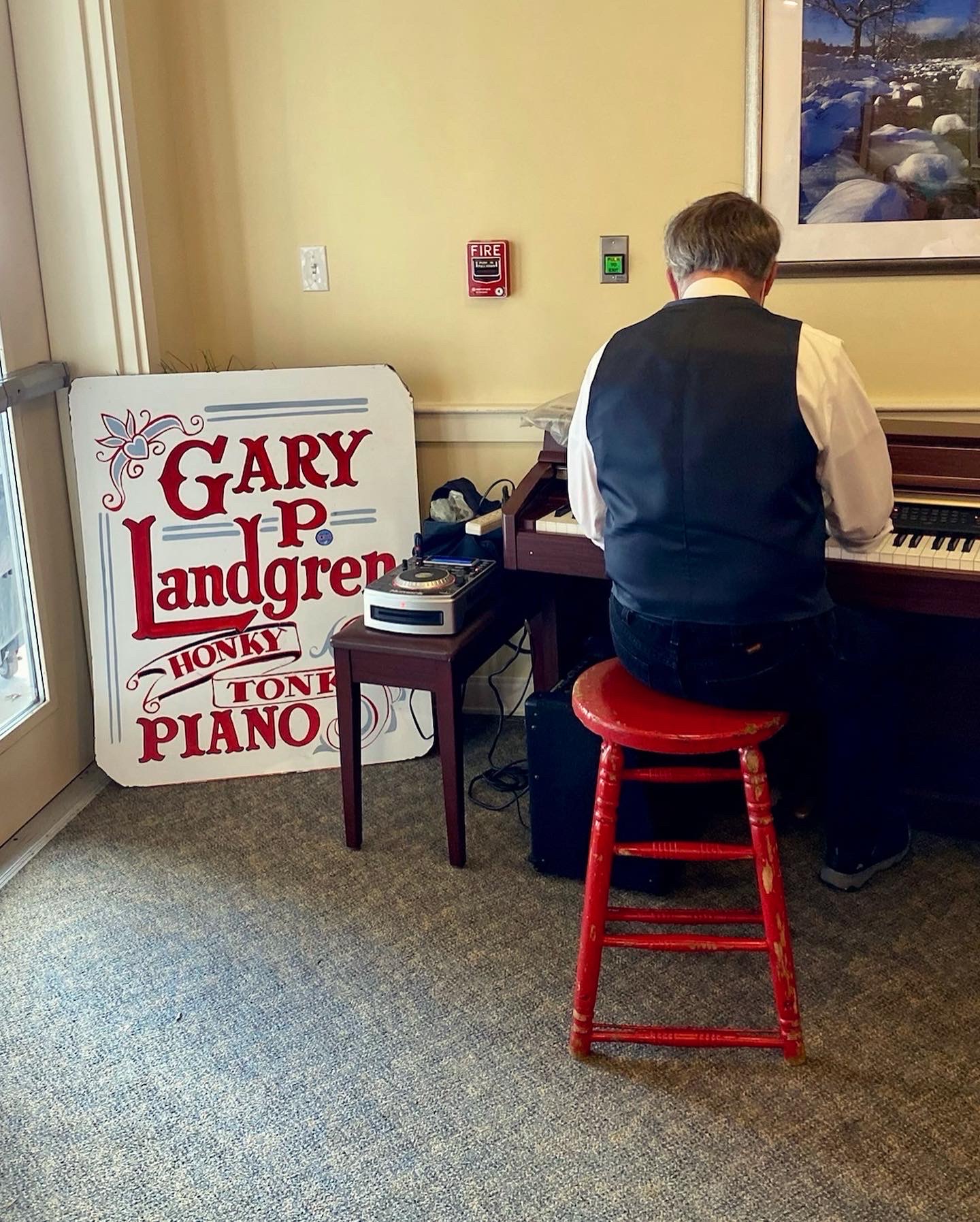 Resident playing piano in an activity room