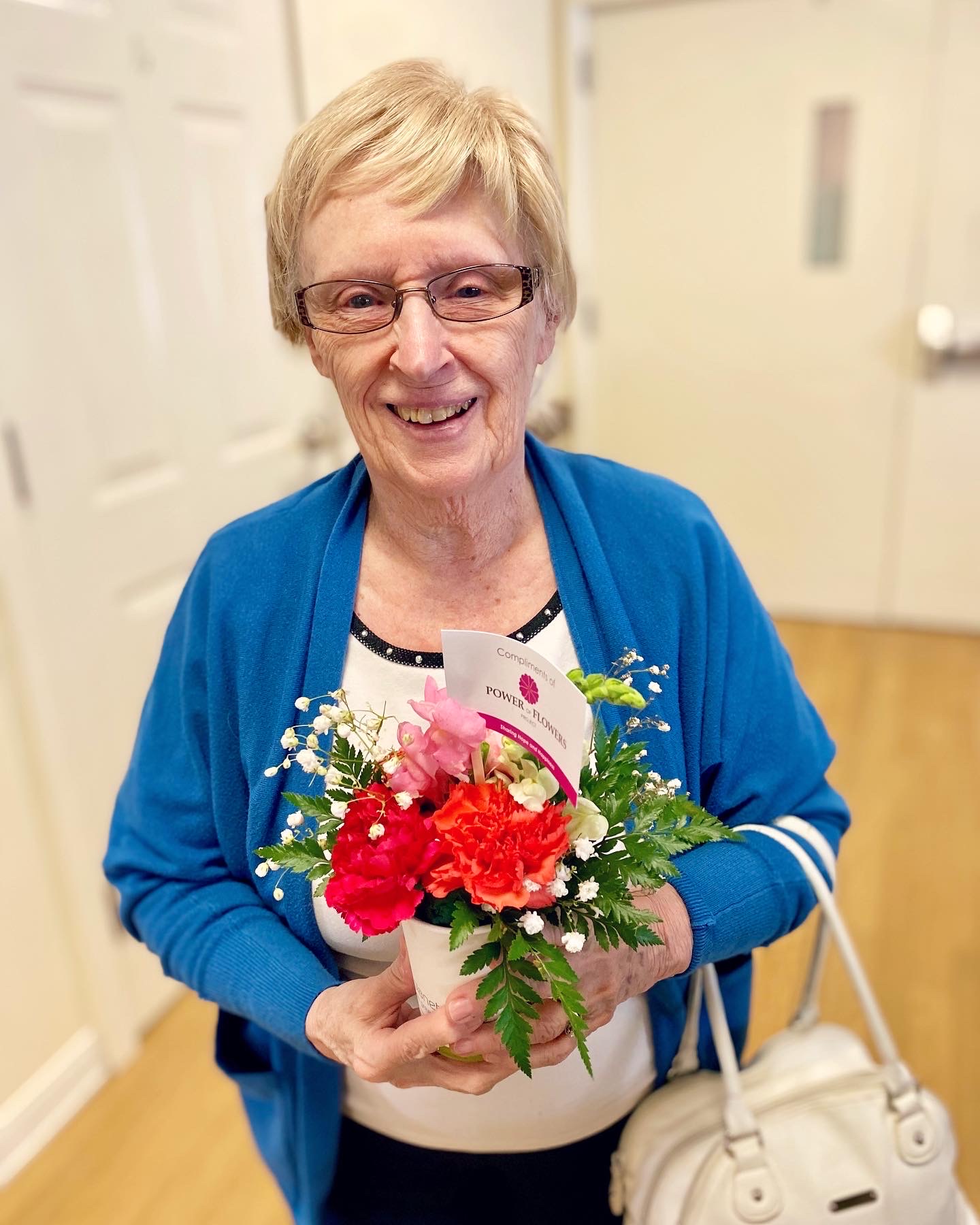 Resident holding a bouquet of flowers in a common area