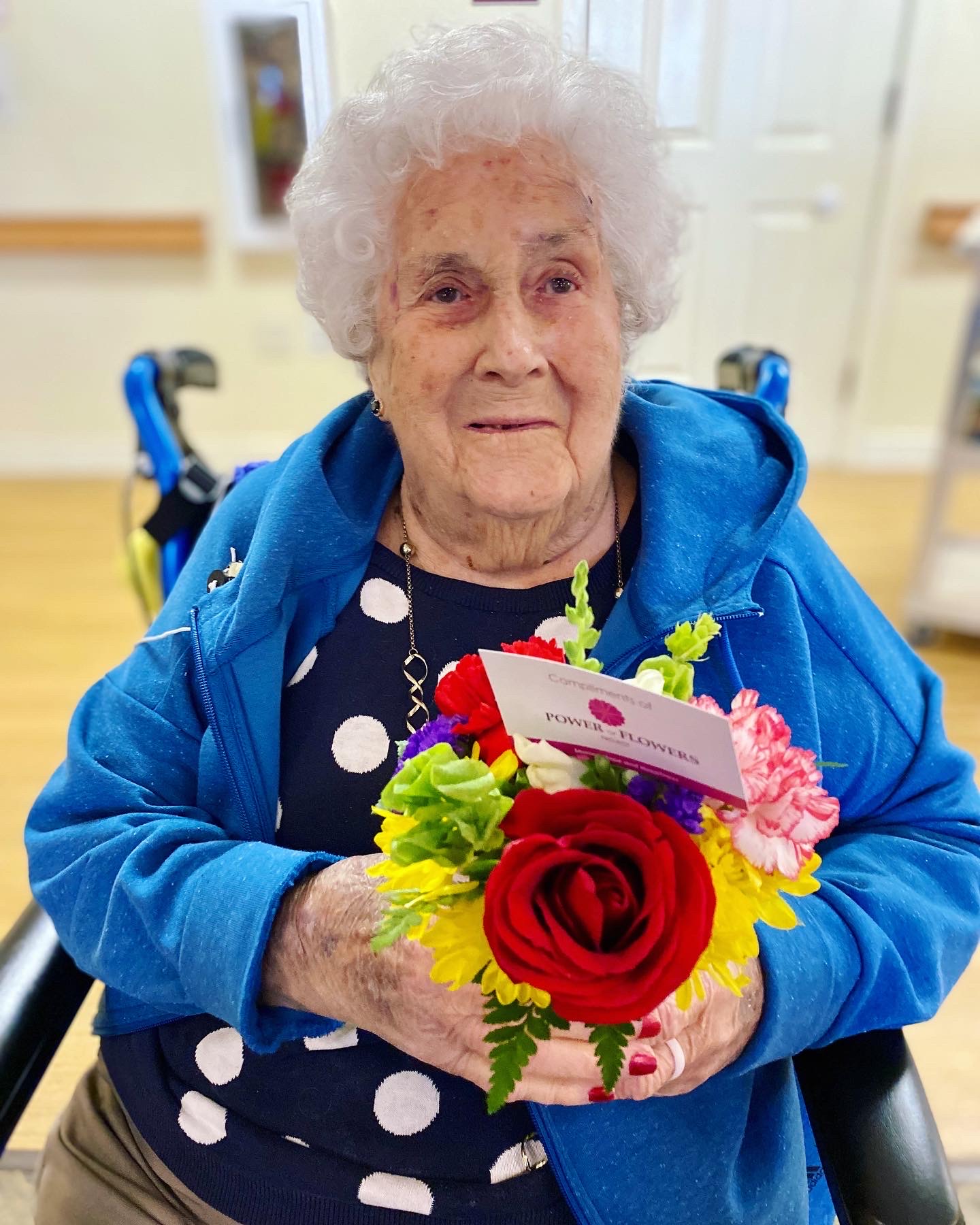 A resident holds a vibrant floral bouquet in a cozy environment