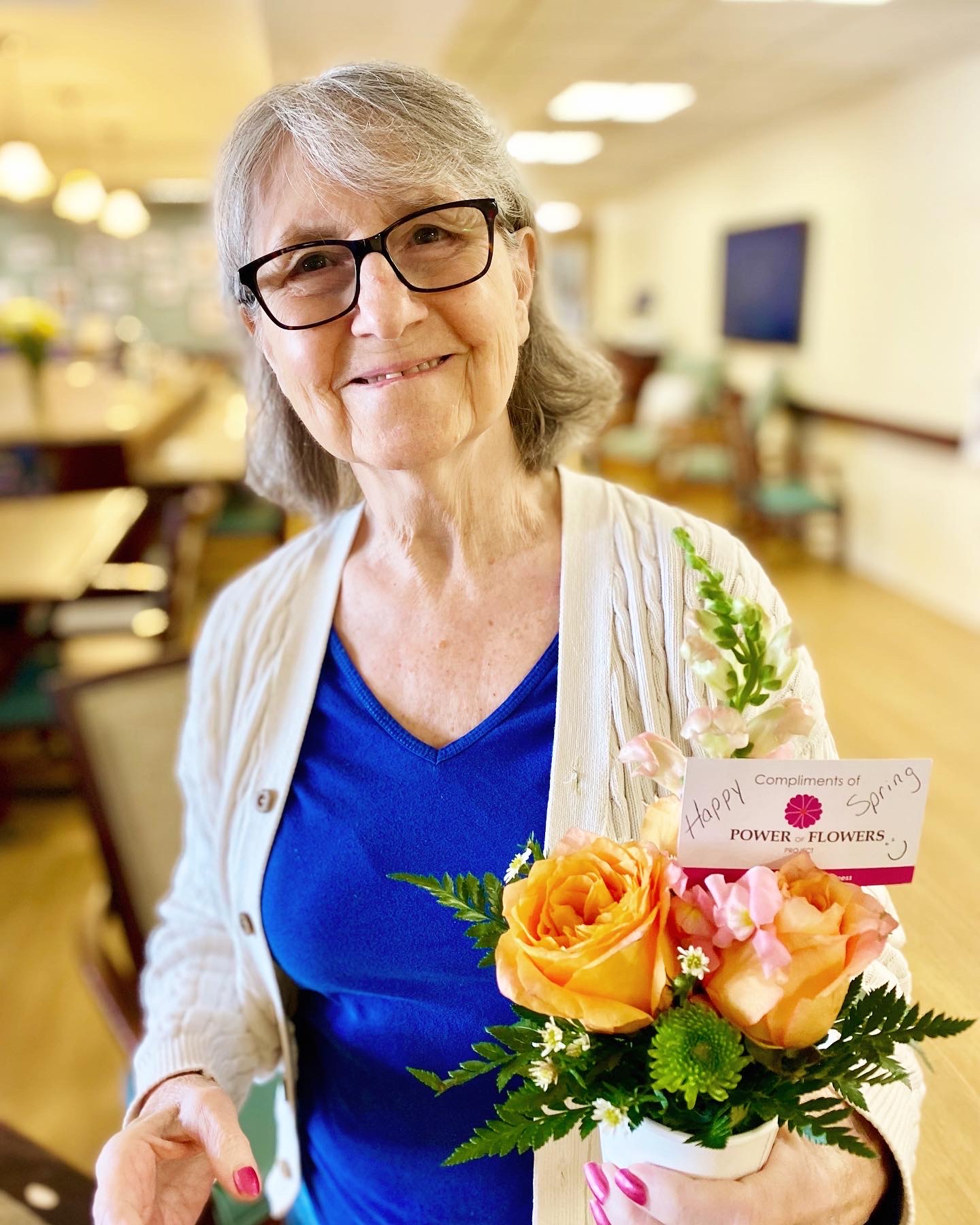 Resident holding a flower arrangement in a common area