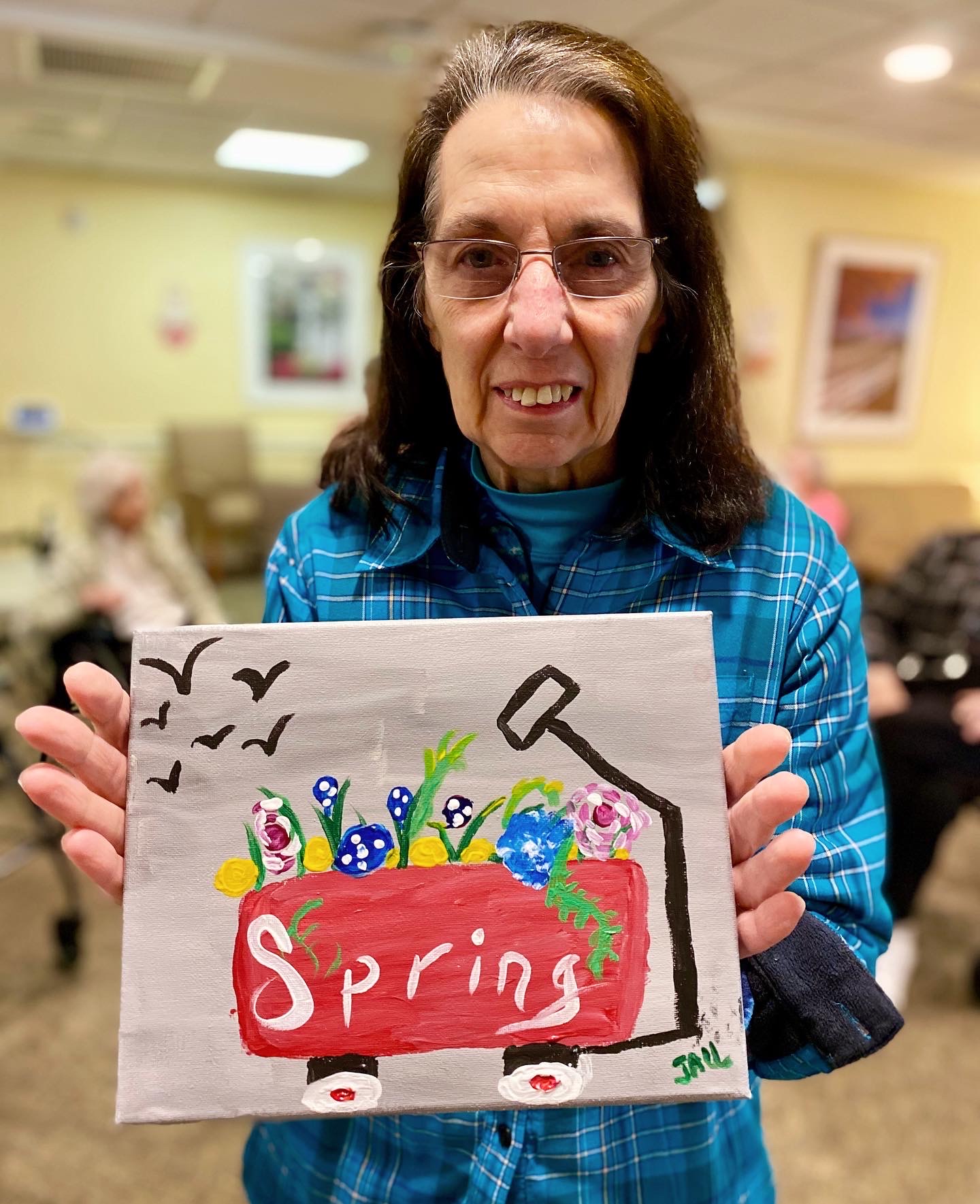 Resident showcasing their spring artwork in a common area