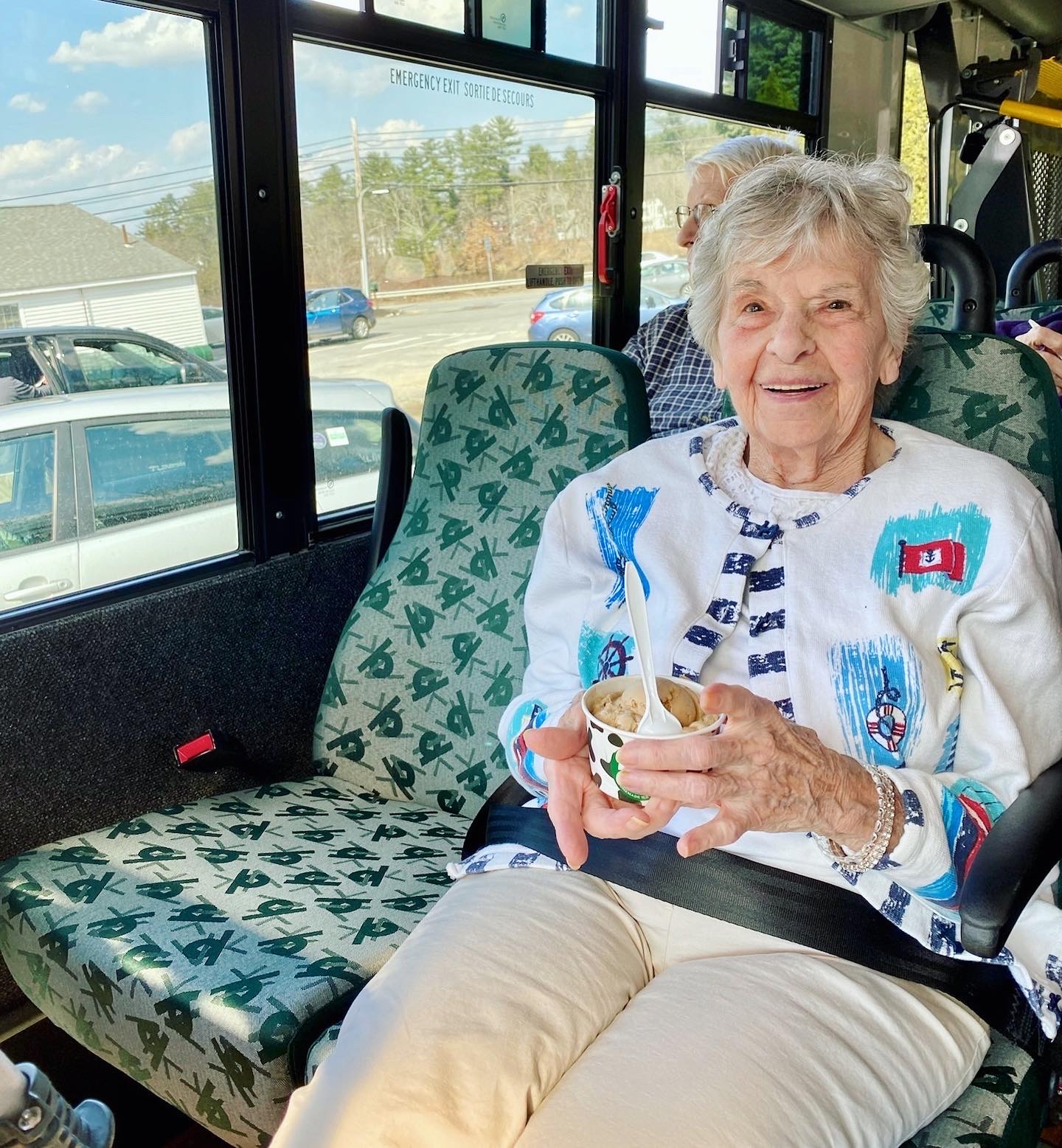 A resident enjoying a snack on a facility bus