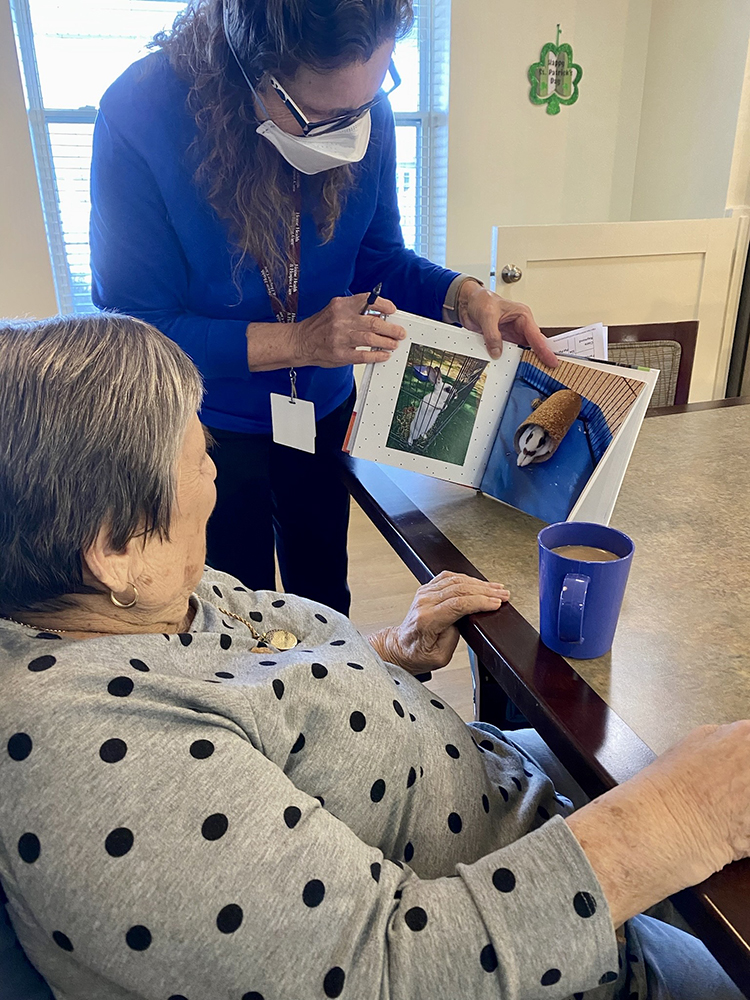 Staff engaging with a resident over a photo book