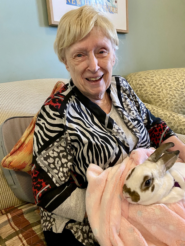 Resident smiling with a rabbit on their lap