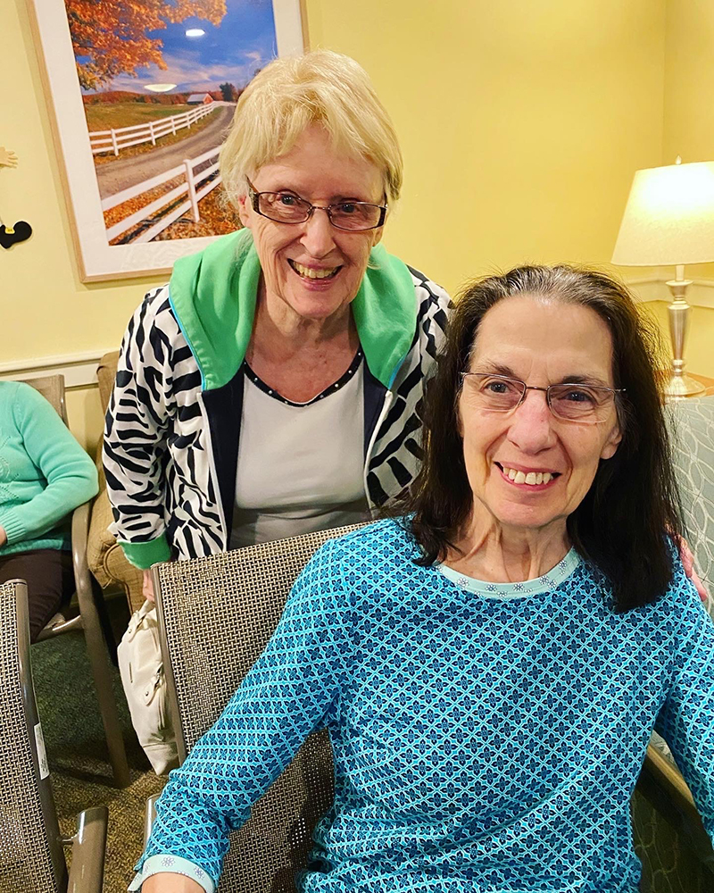 Two smiling residents in a cozy lounge area