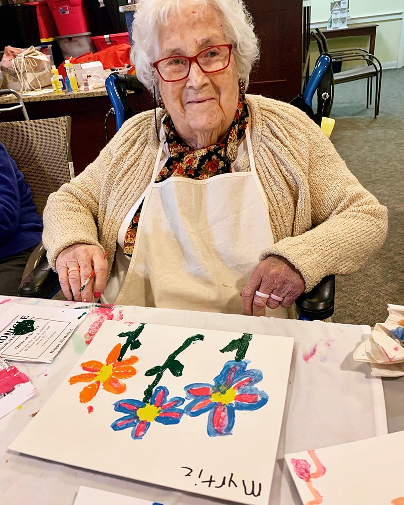 Resident painting flowers during an art activity