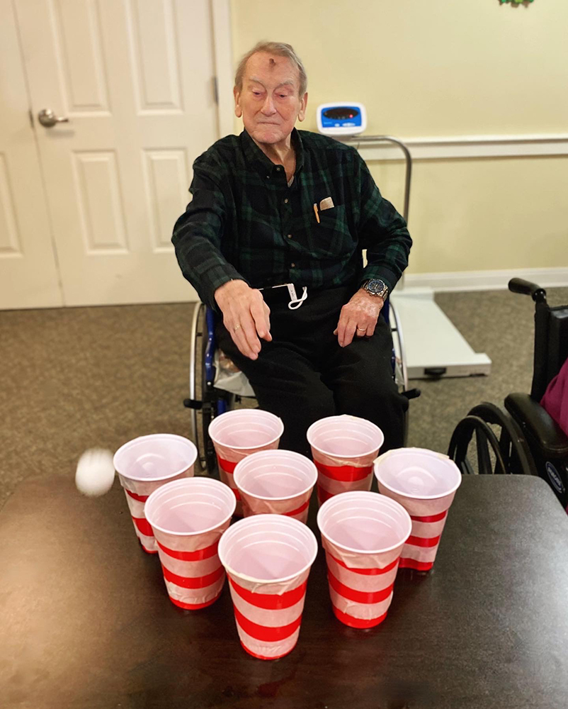 Resident playing an activity game with cups