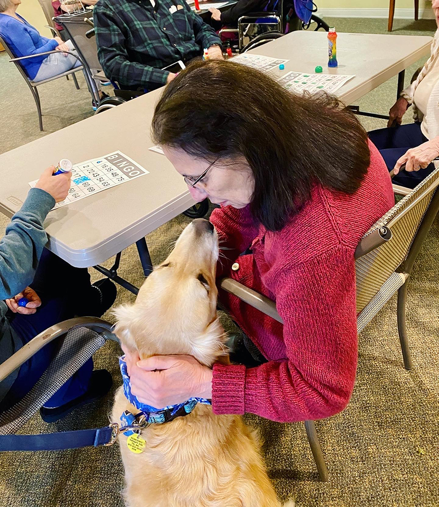 A resident playing bingo with a dog