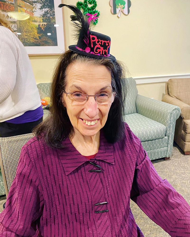 Resident celebrating with a party hat in a lounge area