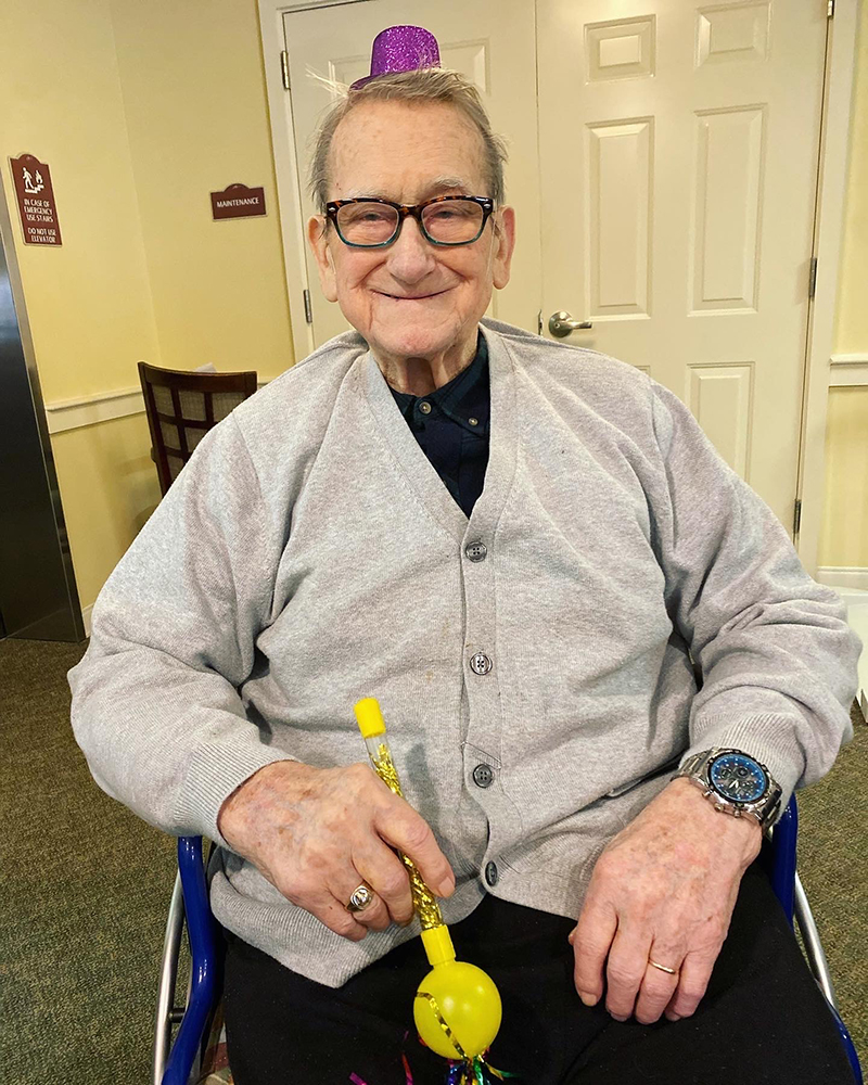 A resident celebrating with a festive hat and noise maker