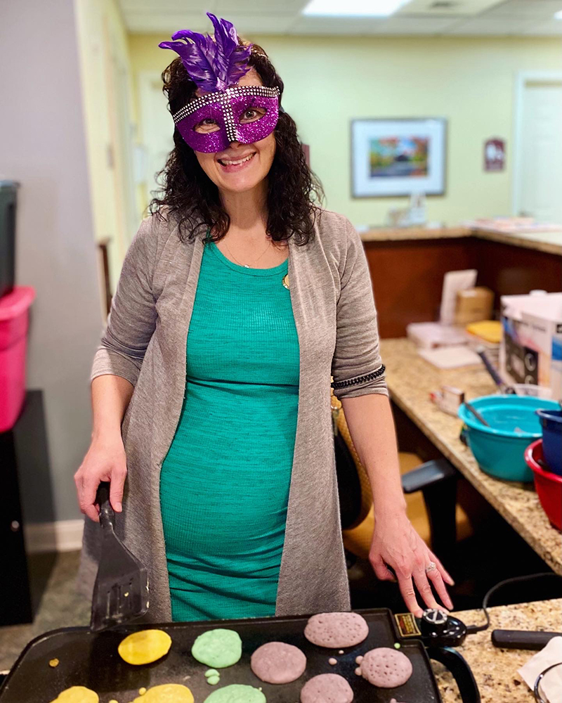 Staff member preparing colorful pancakes during a celebration