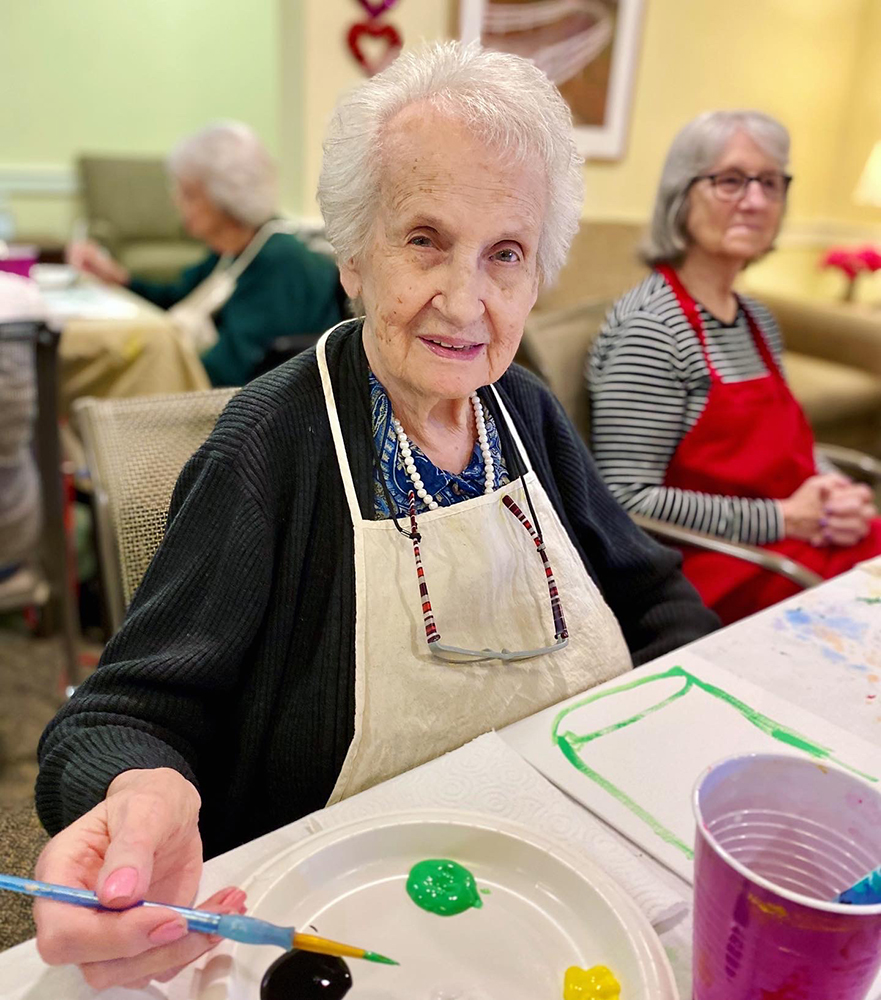 Seniors engaged in a painting activity in a communal space